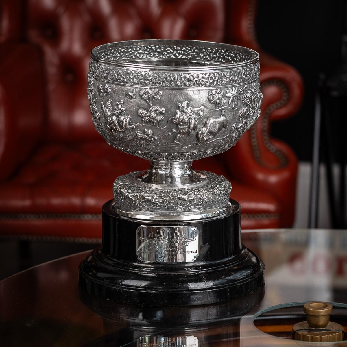 Antique early 20th-century Indian (Lahore / Poona) solid silver bowl on stand, designed in a traditional shape with a large domed foot, resting on a large ebonised presentation stand. The bowl features intricate and ornate embossing, with a top band
