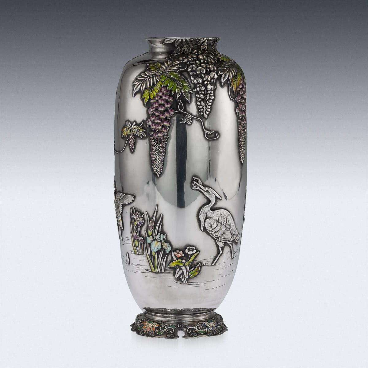 Antique early 20th century Japanese Meiji period solid silver and enamel vase on quarto-form base with enameled scrolling foliage, the sides chased and applied with enameled wisteria, exotic birds amongst a continuous riverside landscape. Hallmarked