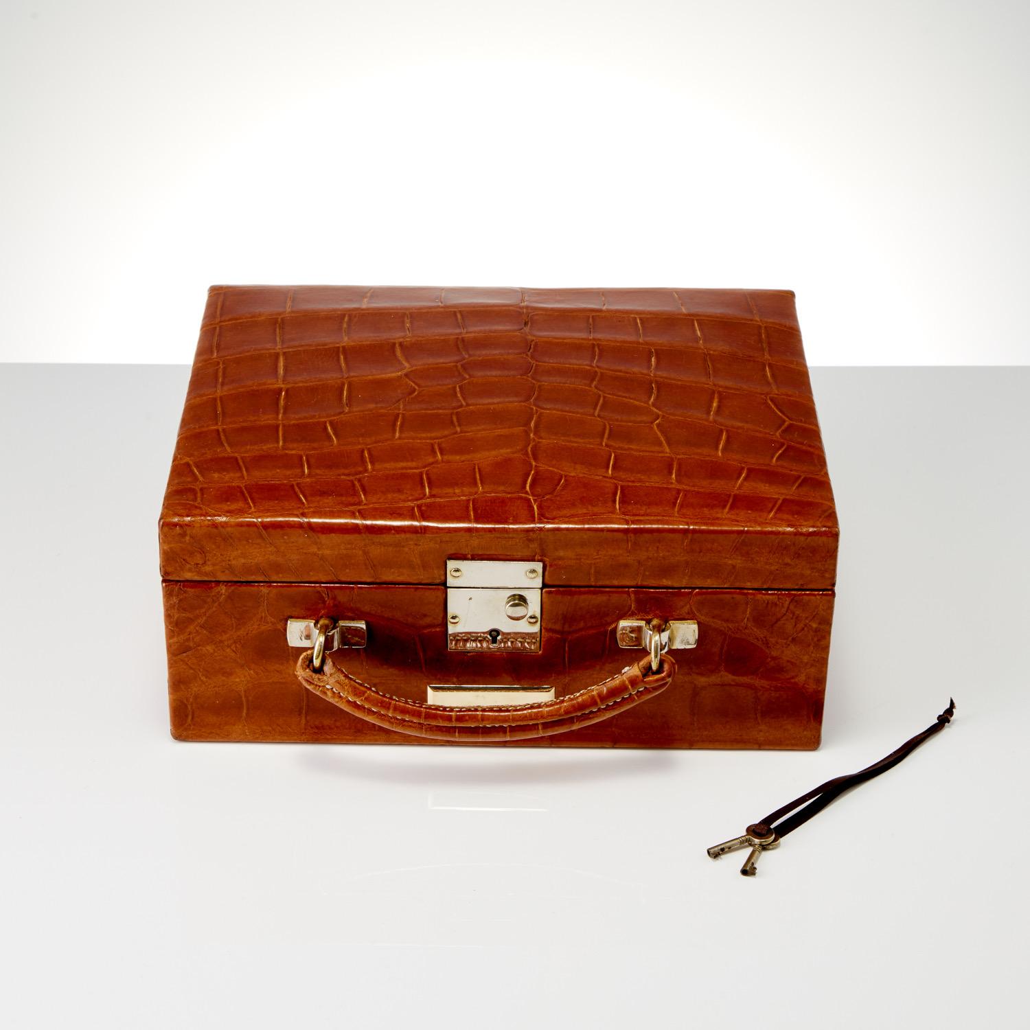 An Antique 20th Century Leather Travel Case For Jewellery, Circa 1930. 

This piece appears to be in unused condition, the exterior crocodile skin retains its original patina throughout including the base. 
The interior is lined throughout in a soft