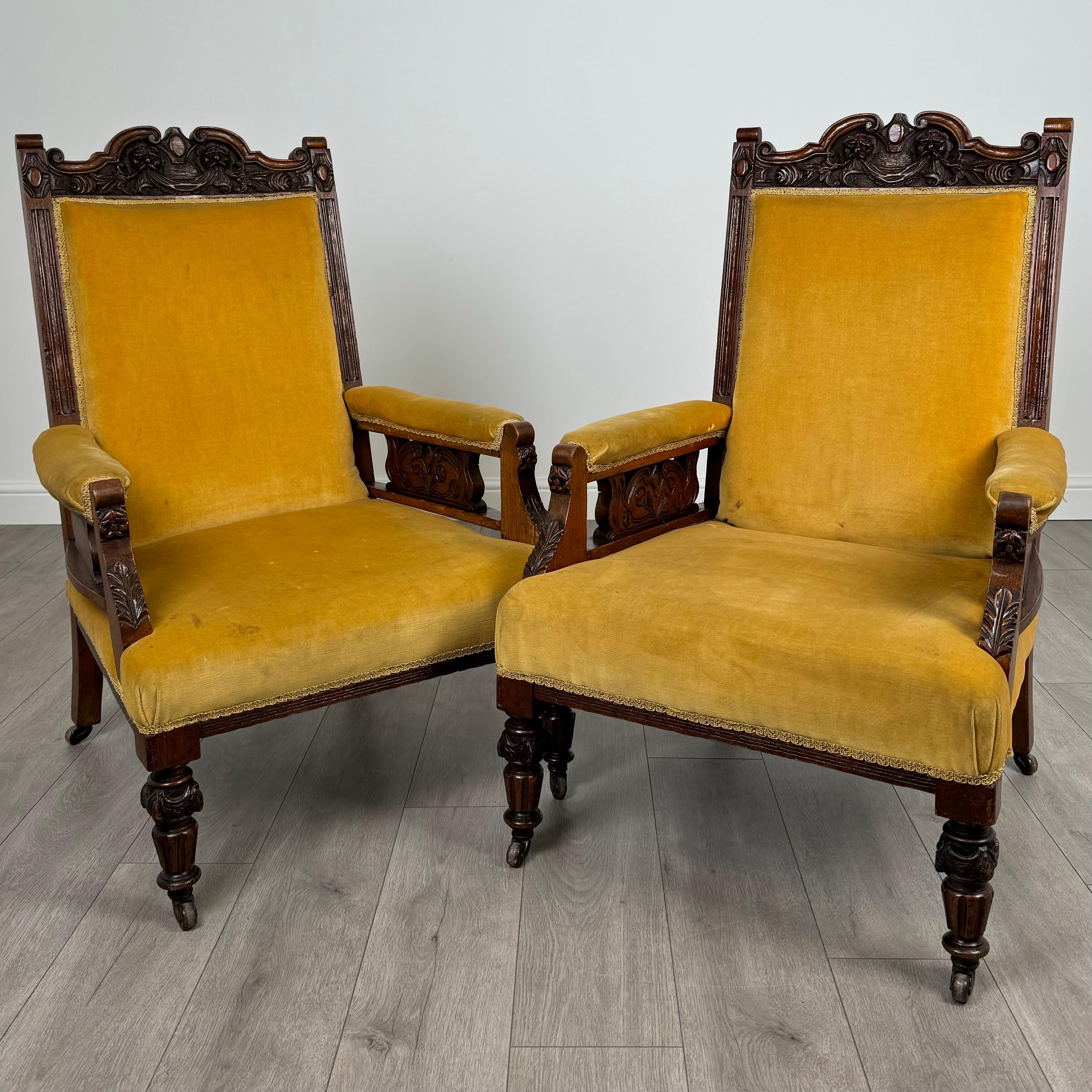 Questa antica coppia di poltrone intagliate del XX secolo, realizzate in rovere massiccio, emana eleganza e carattere. Dal design accattivante, ogni sedia poggia su robuste gambe tornite ed è dotata di rotelle per un facile spostamento. Le cornici