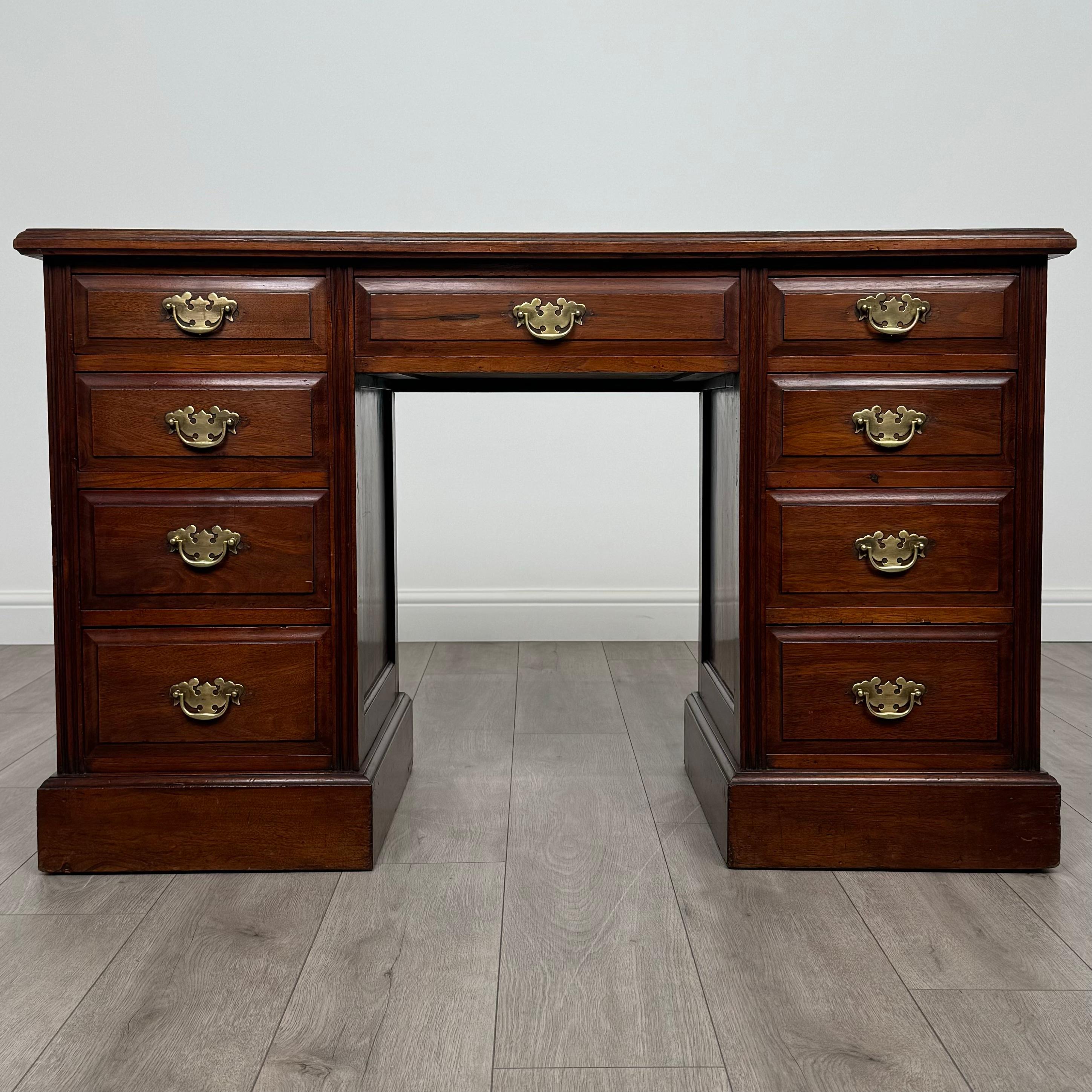 Cet élégant bureau à piédestal du XXe siècle, fabriqué dans un riche noyer, est une pièce magnifiquement conçue et très fonctionnelle. Reposant sur un socle robuste, il offre un aspect intemporel et sophistiqué, parfait pour un bureau, un home