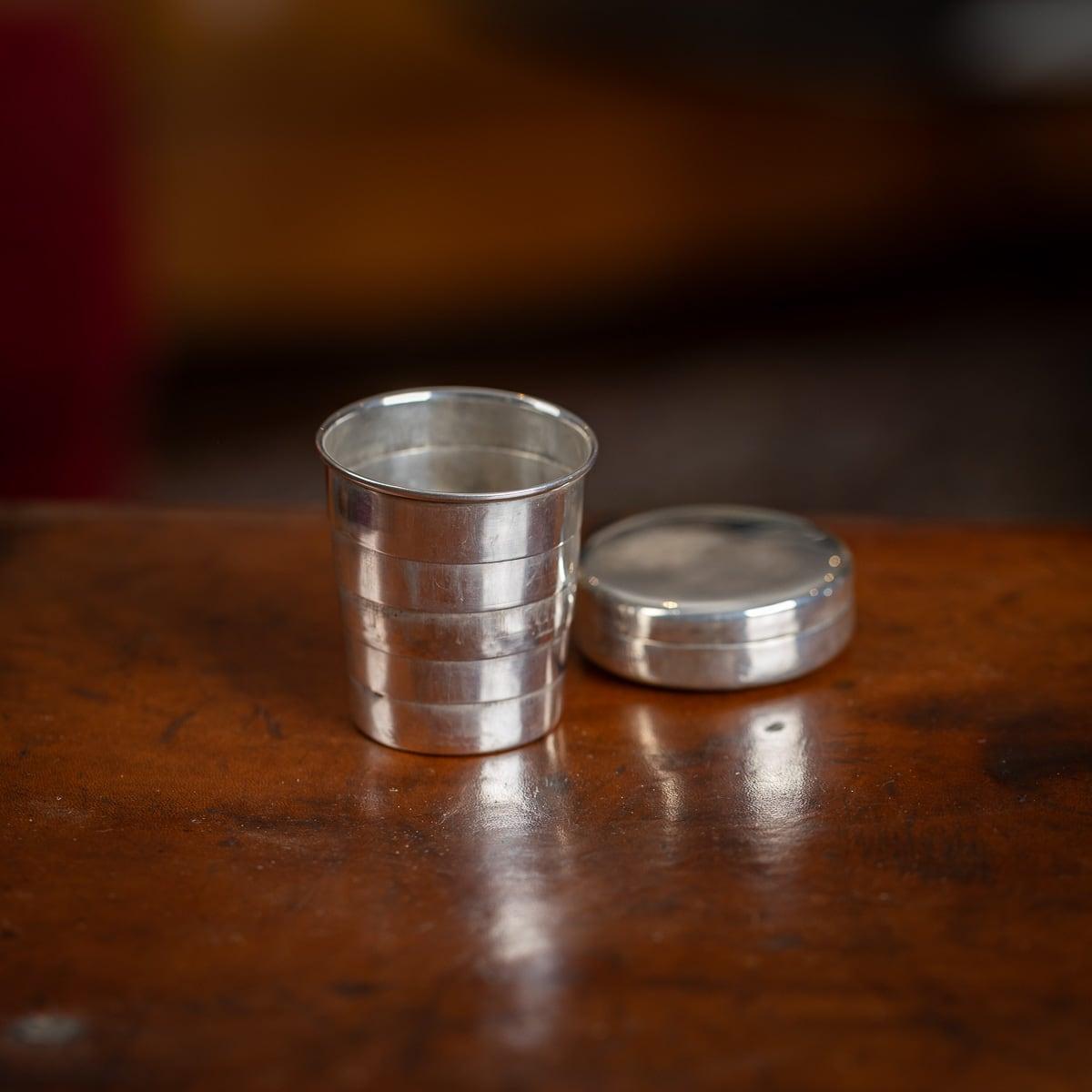 Ancienne tasse de voyage pliable en argent massif du début du 20e siècle. De taille compacte, avec un corps effilé composé de cinq pièces, il se range parfaitement dans un étui de voyage de poche en argent massif. Présenté dans un étui zippé en cuir