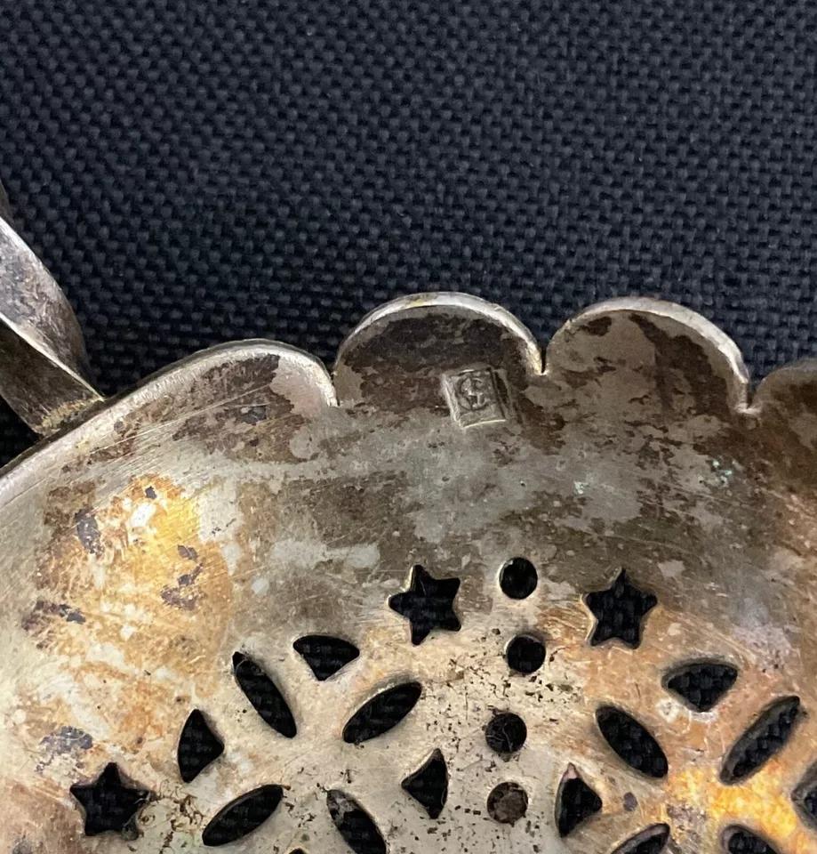 Questo antico cucchiaio per setacciare lo zucchero in argento ritorto del XX secolo è un pezzo di stoviglie vintage affascinante e funzionale. Originario della Francia, incarna l'eleganza e la praticità, rendendolo ideale per compiti delicati come