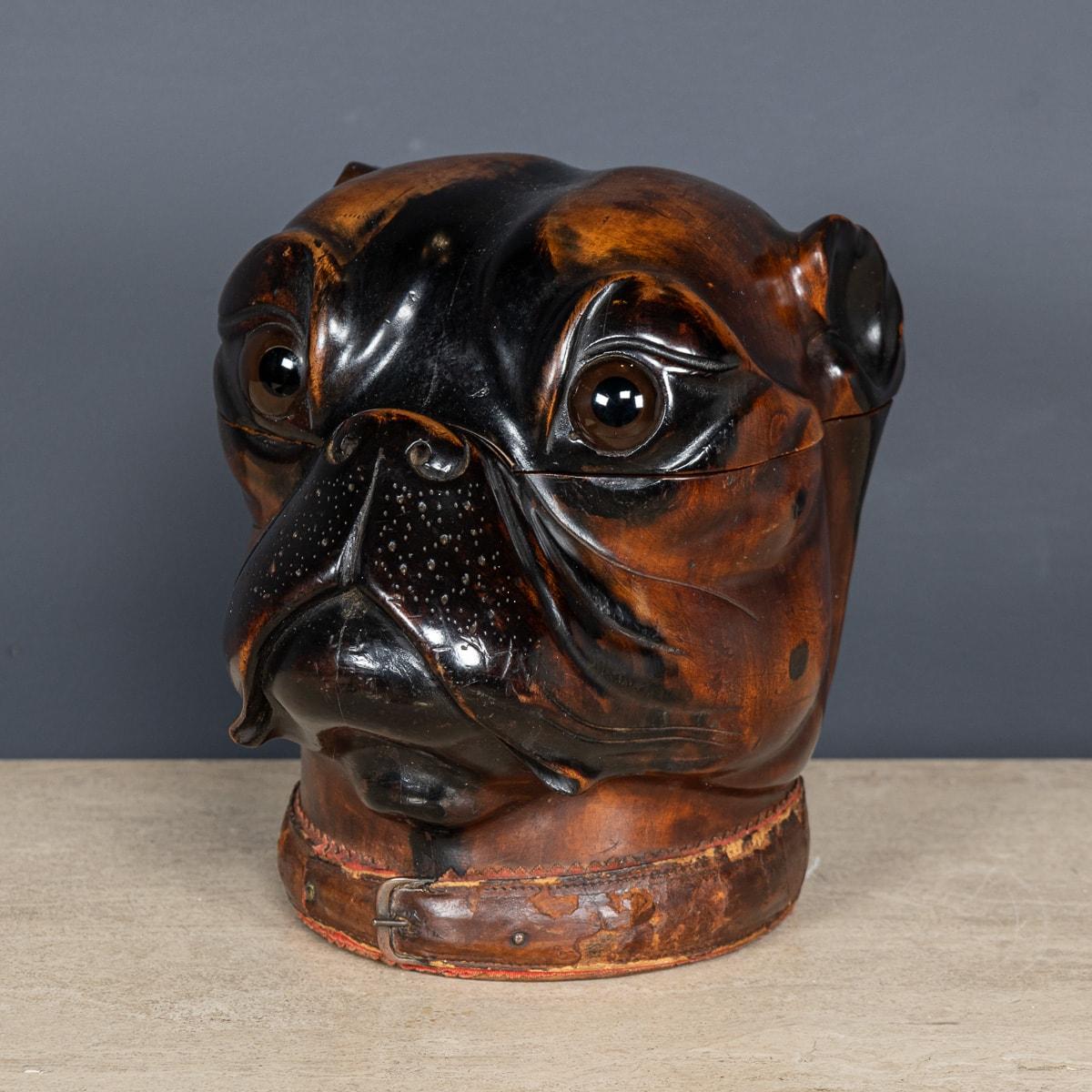 Antike viktorianische Lignum-vitae-Tabakdose des frühen 20. Jahrhunderts, geschnitzt in Form eines Bulldoggenkopfes. Die Details sind von außergewöhnlicher Qualität, mit großen Glasaugen und einem Lederband um den Sockel. Sie ist innen mit Messing