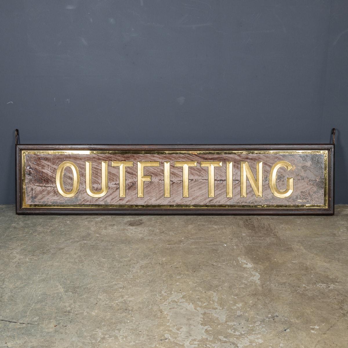A wonderful early-20th Century Victorian mirrored reverse painted outfitting sign from Harris Tweed Outfitters. This sign with painted gold letters on a pale pink textured background with a gold border. Boxed in with mahogany, static iron hooks