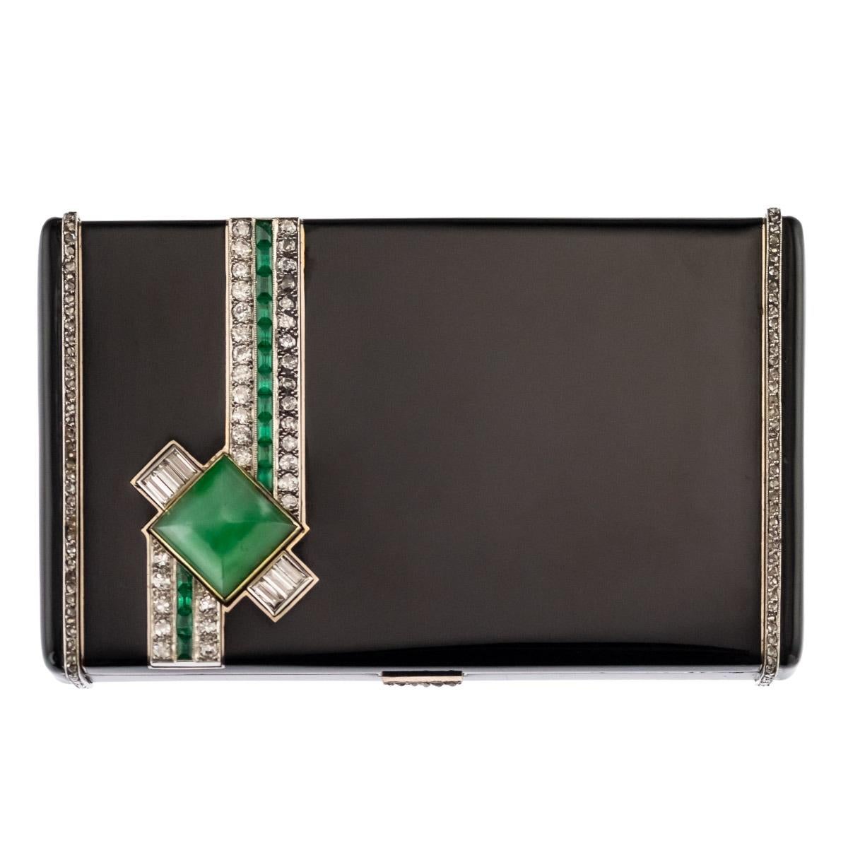 Antique early-20th century French Art Deco 18-karat gold vanity case, of rectangular form with rounded corners, the lid set with a pyramid shaped jade, rows of diamonds and emeralds, set in platinum, the whole box is applied with black lacquer. The