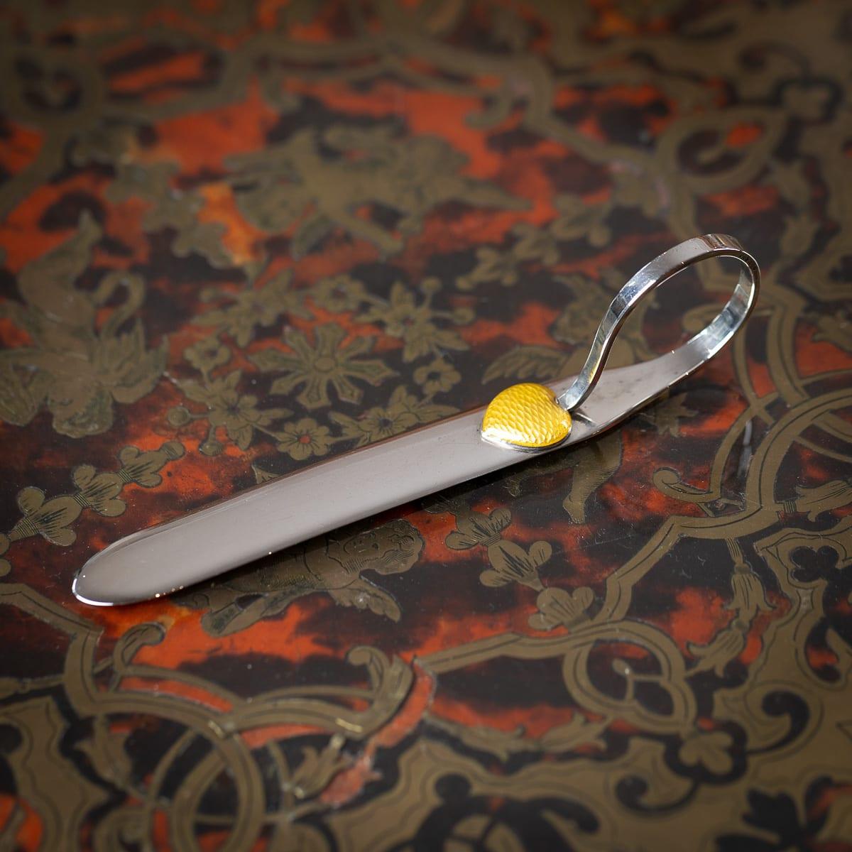 Antique 20th Century Austrian solid silver letter opener of flat form with a gently curved handle, terminating in a yellow guilloché enamel heart. Hallmarked with Austrian markings.

Hallmarked 900 silver grade, Makers mark 