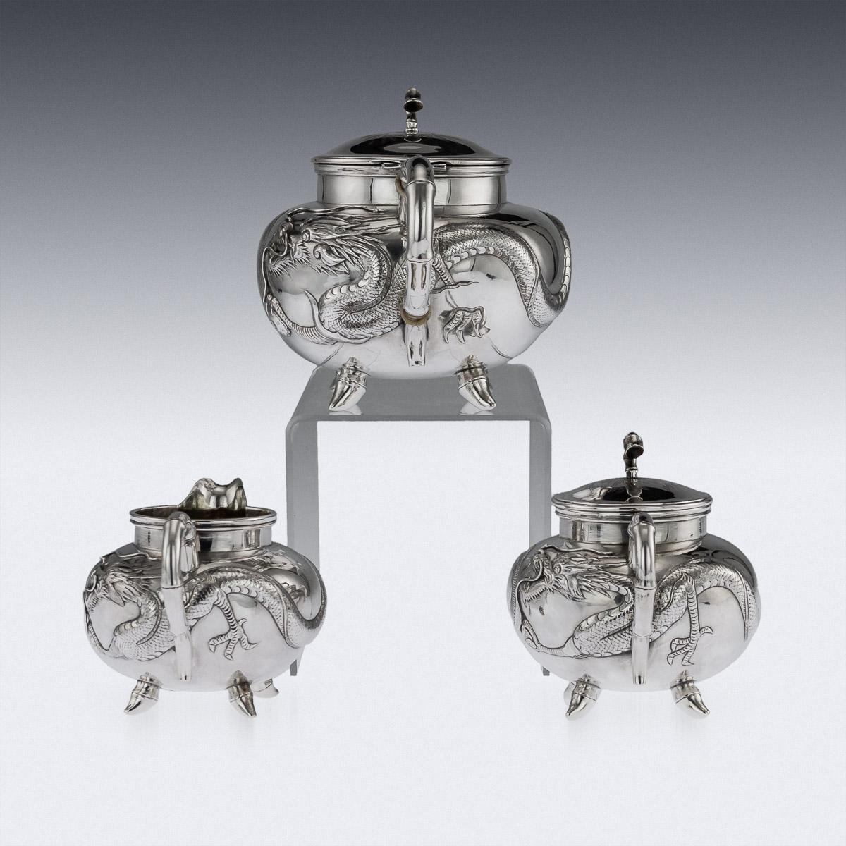 Antique early 20th century Chinese export solid silver three piece tea set, comprising of teapot, sugar bowl and milk jug, each spherical body applied with dragons in relief, spout, handle and feet modelled as a bamboo branch and richly parcel gilt