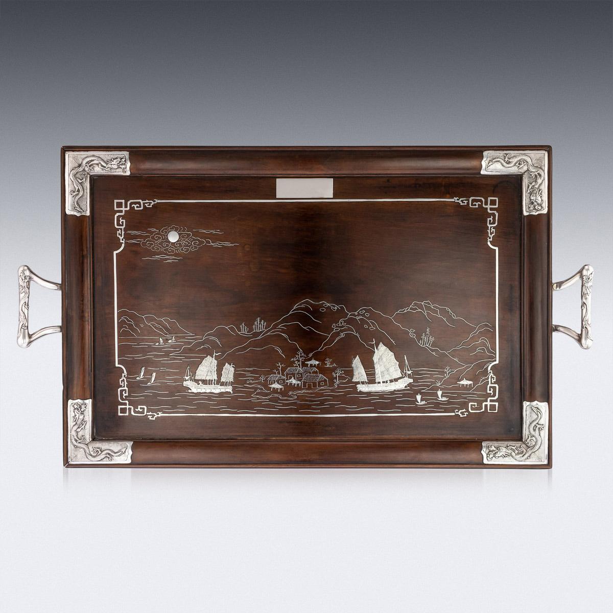 Antique early 20th century rare Chinese export solid silver impressively large, detachable tea tray on a folding table, handles and corner plaques embossed with a dragon design on matted ground. Mounted on a large rosewood serving tray, of
