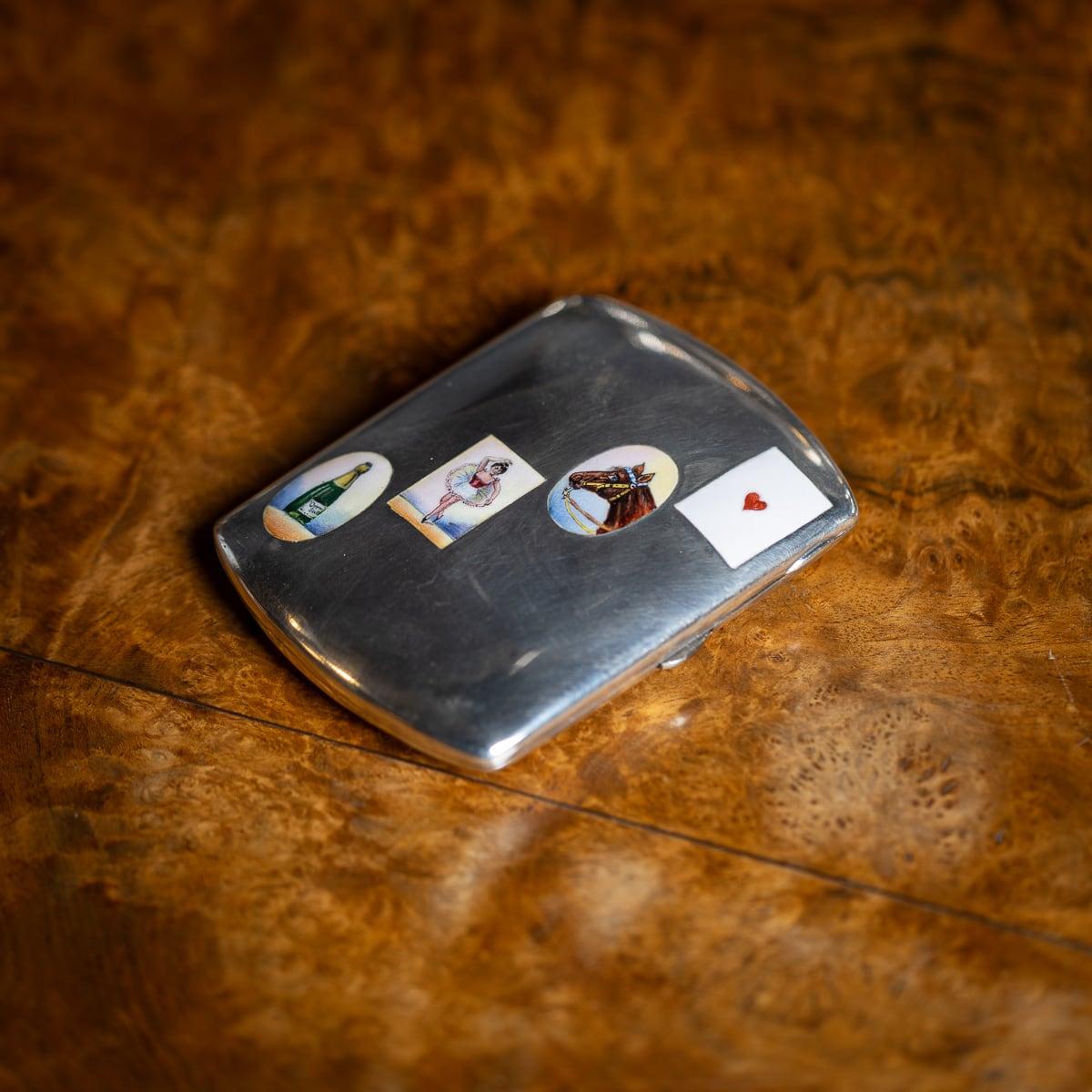 Antique early 20th Century German solid silver & enamel cigarette case. The front is adorned with four vices painted in enamel: a horse's head (sports), a champagne bottle (drinking), a ballet dancer (women), and a playing card featuring a heart