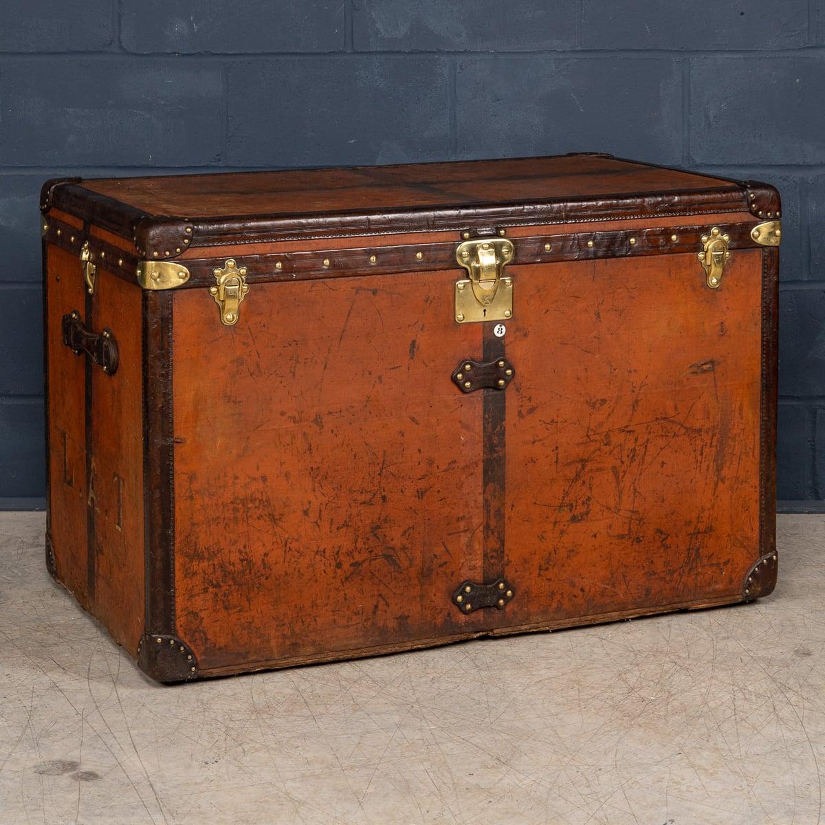 A Louis Vuitton “high trunk” trunk (from French “Malle Haute”), circa 1900's, featuring orange “Vuittonite“ canvas, all brass hardware, and leather trims. Trunks in this type of finish are more scarce than its monogrammed brothers. It is a stain and