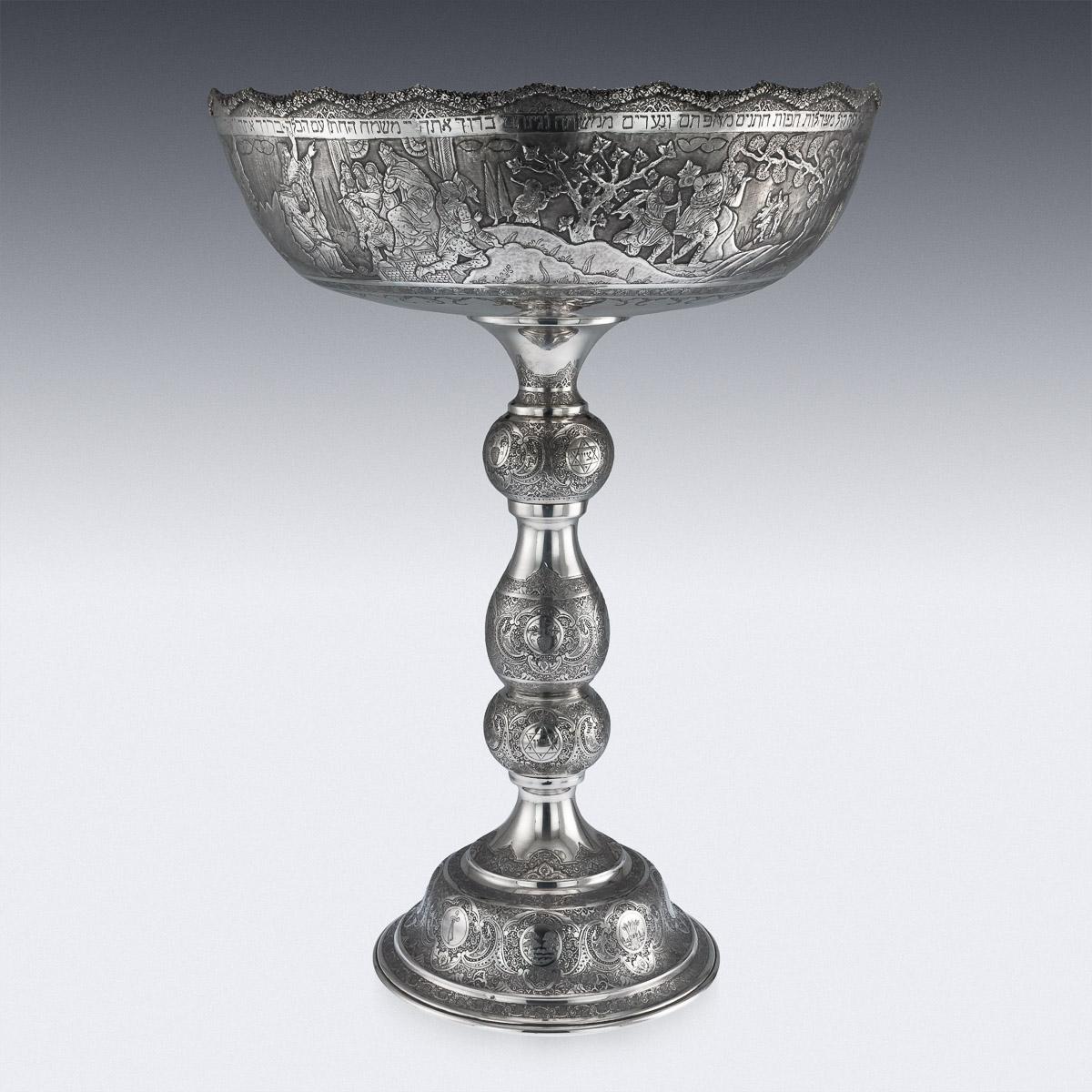 Antique 20th century Persian Jewish monumental solid silver centrepiece tazza, of very large size, profusely decorated with Persian traditional scrolling design, originating from the city of Isfahan, applied cast wavy borders, the bowl depicting the