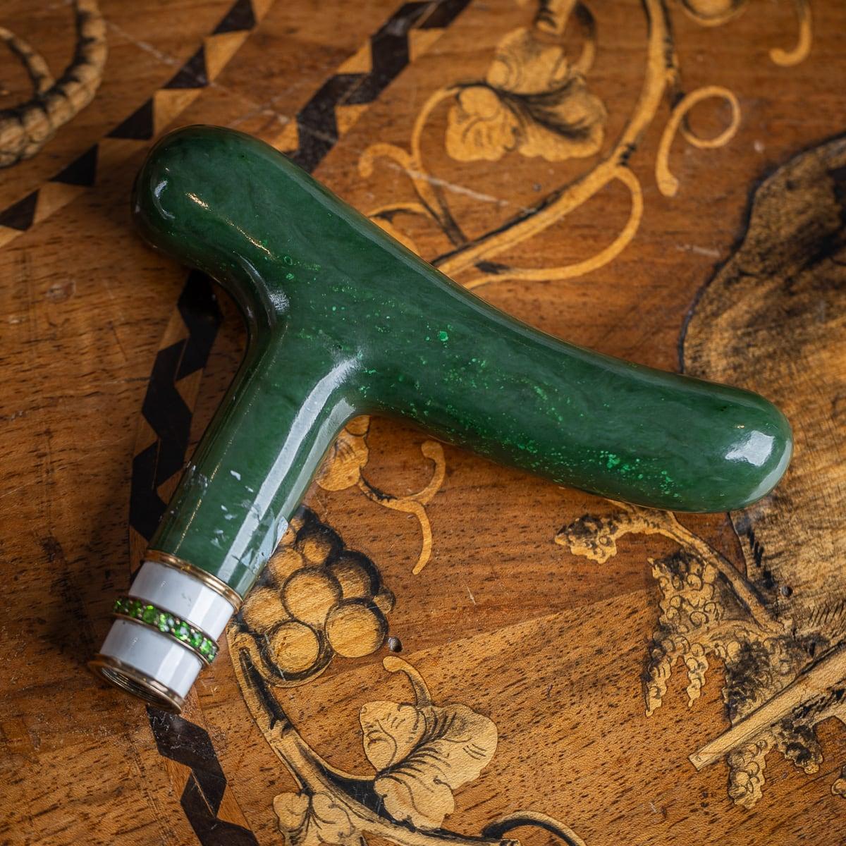 Antique early-20th Century Imperial Russian style 18k gold mounted nephrite cane handle, applied with nineteen round cut Peridots around the white enamel base. Cane handles crafted from carved nephrite and set with gemstones showcase the opulence