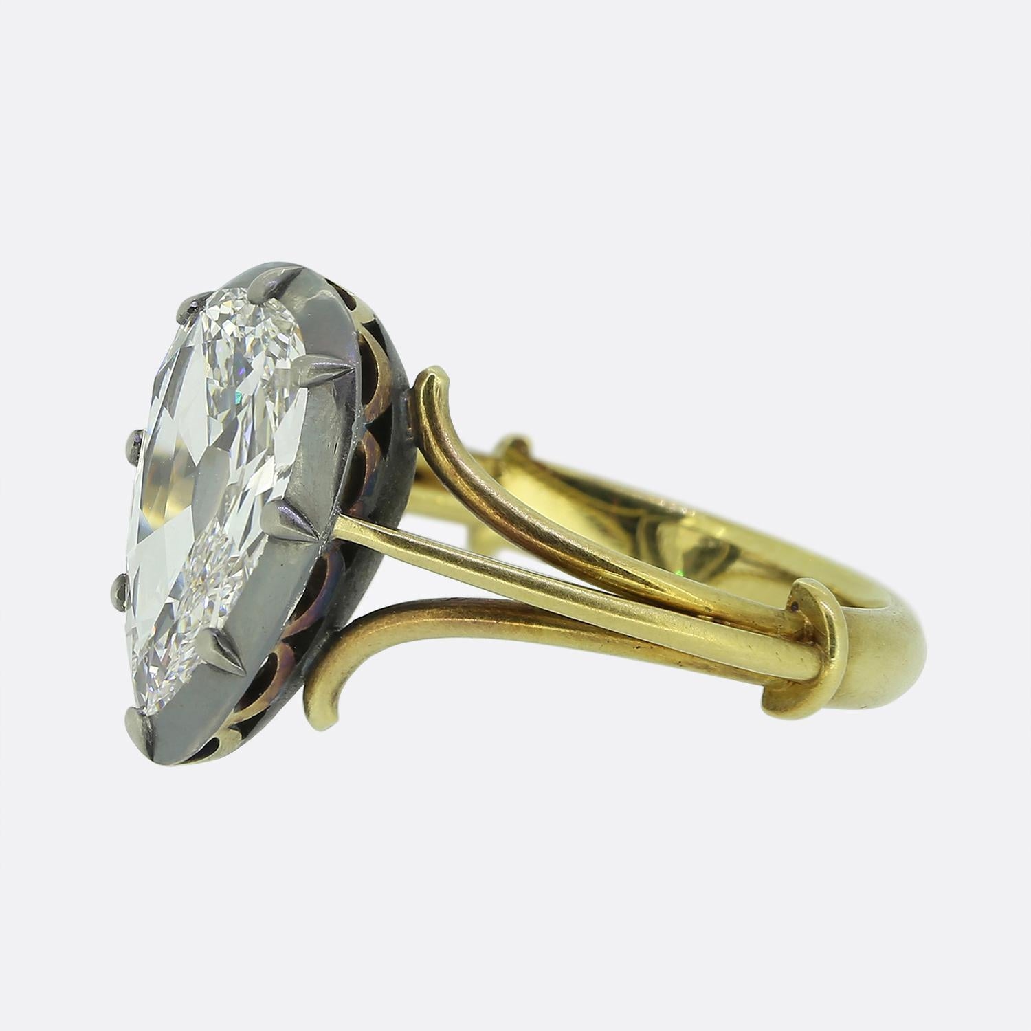 Ecco un sorprendente anello solitario con al centro un importante diamante taglio vecchio a forma di pera. Il diamante è incastonato in una robusta montatura d'argento, che ne accentua il colore e la purezza. La fascia, realizzata in oro giallo 18