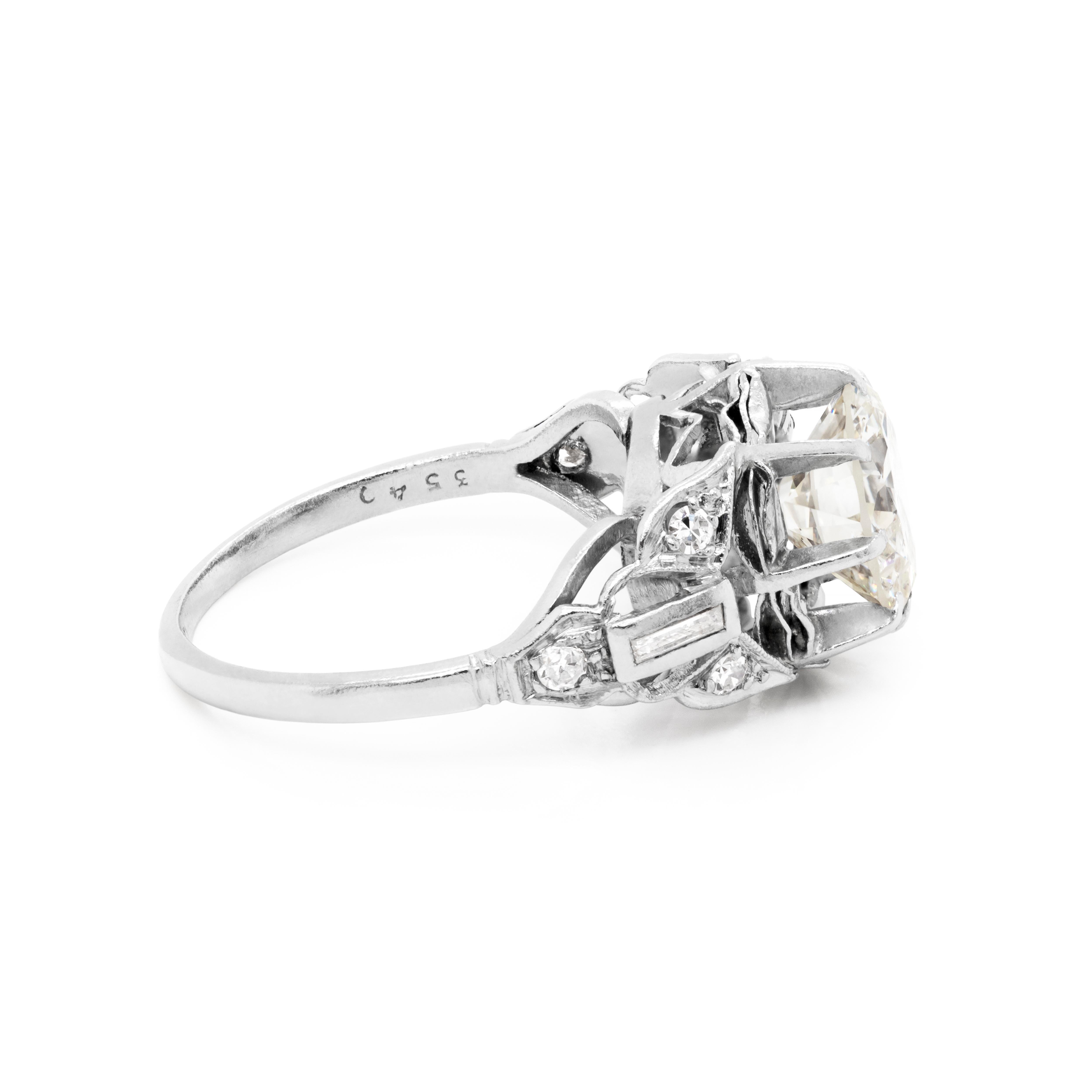 Original Edwardian handmade engagement ring featuring a 2.11 carat transitional cut diamond set in an open work, elevated eight claw setting. This incredible ring is intricately designed with open work shoulders, rubover  set with a baguette cut