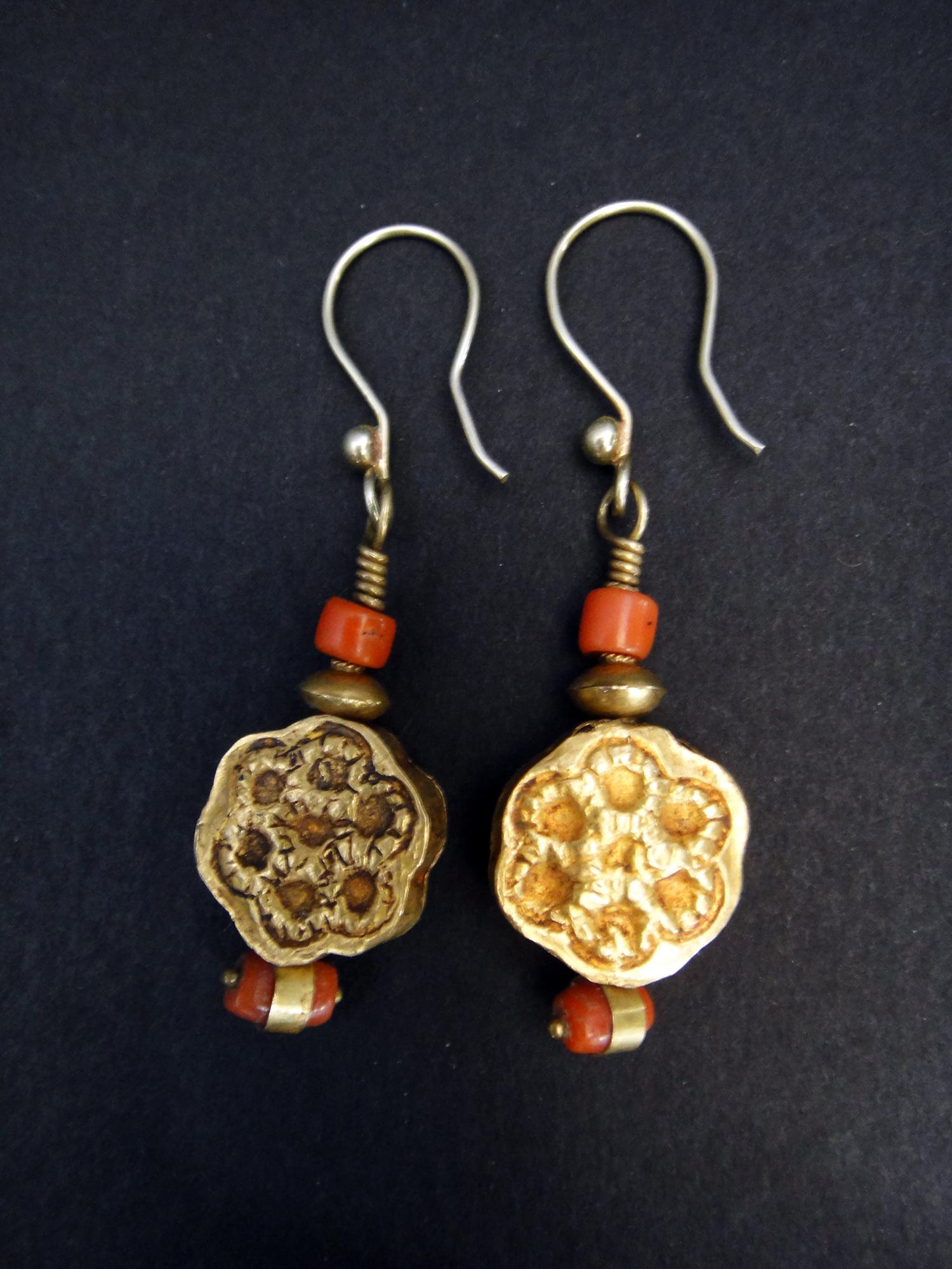 These unique, antique earrings are from Pakistan. The 21k gold beads feature a delicate flower design, the natural coral beads are the perfect accent stones for this lovely pair of earrings. 