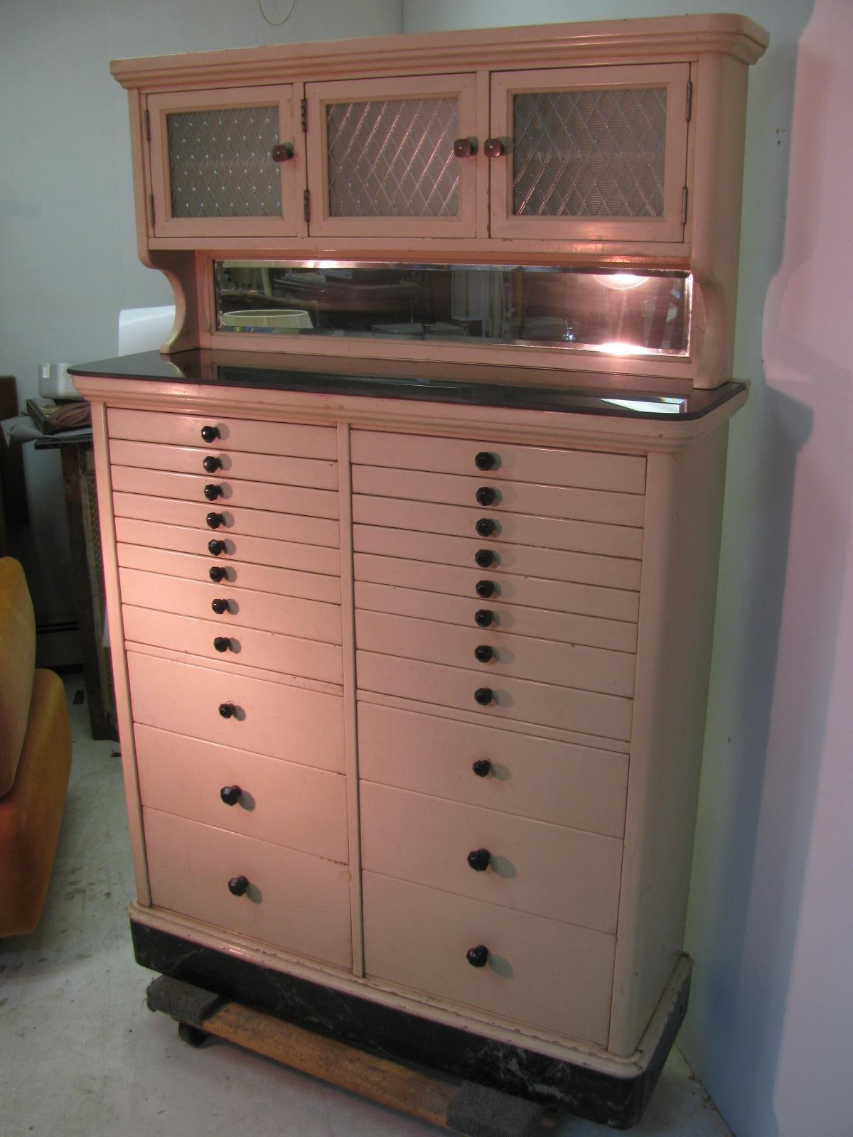 Beautiful and amazing cabinet built for the medical field, specifically dentists. 22 drawers with a 3 door cabinet up top with textured glass. Original paint with a 2 piece black glass shelf. All drawers open easily with black glass knobs and