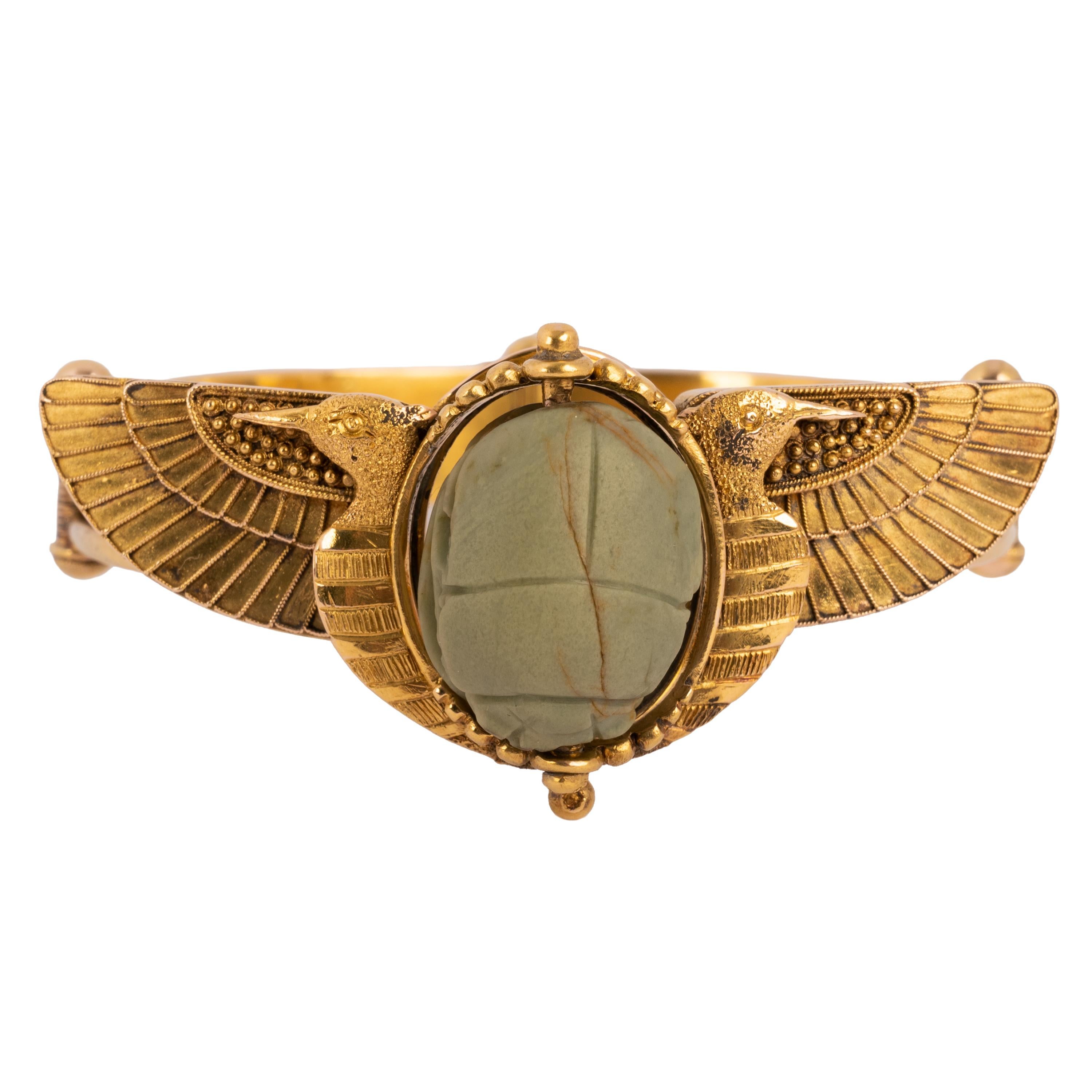 A rare antique Egyptian Revival 22 karat gold bracelet, circa 1870. Gold weight 38.10 grams.
This continental gold bracelet tests as 22 karat gold and is fitted with a green faience ancient Egyptian scarab, engraved with Hieroglyphics. The front of