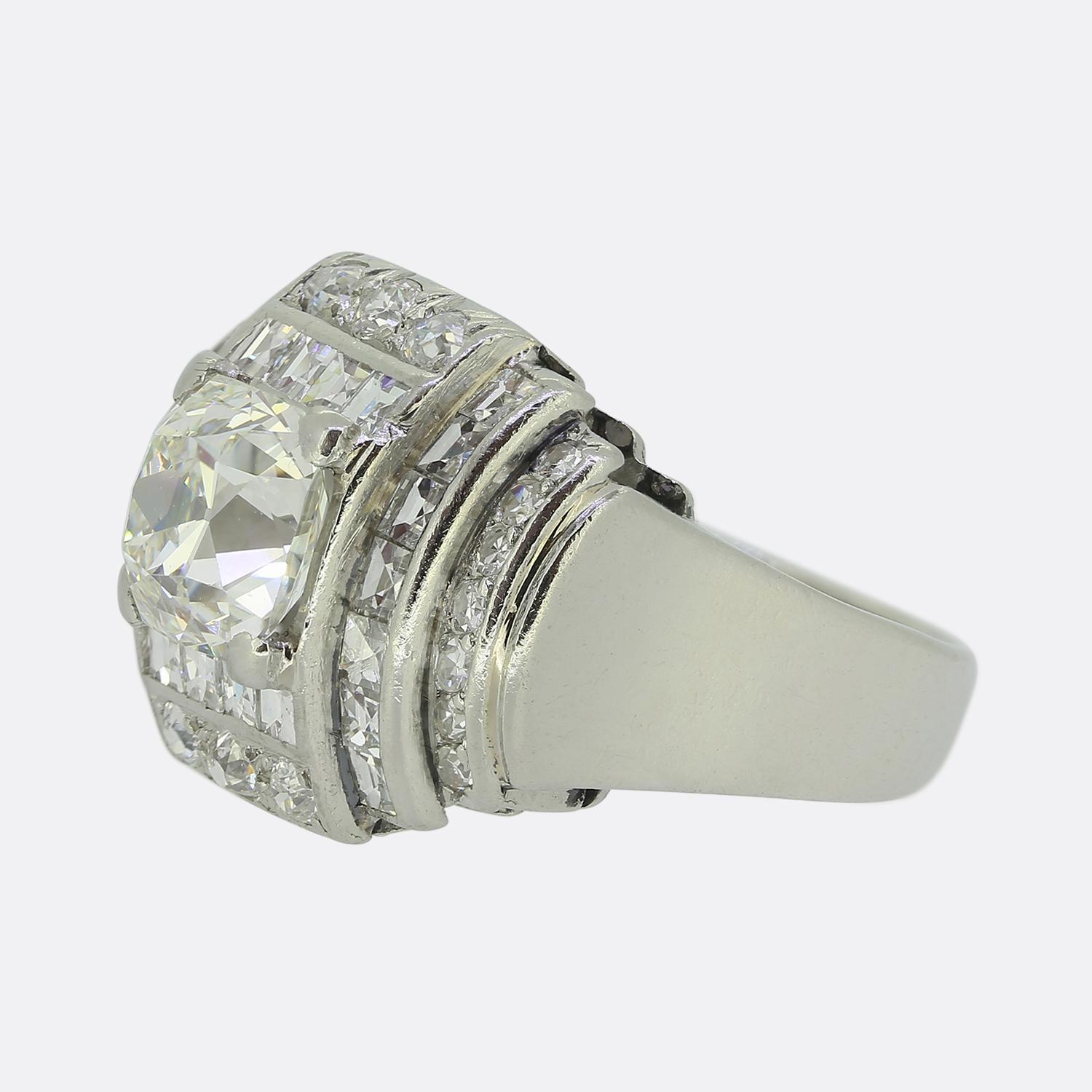 Here we have an exceptional cluster ring crafted from platinum during the mid-way point of the 20th century. This multi-layered piece focally features a remarkable 2.22 carat peruzzi cut diamond expertly set at the centre of a bold a geometric face.