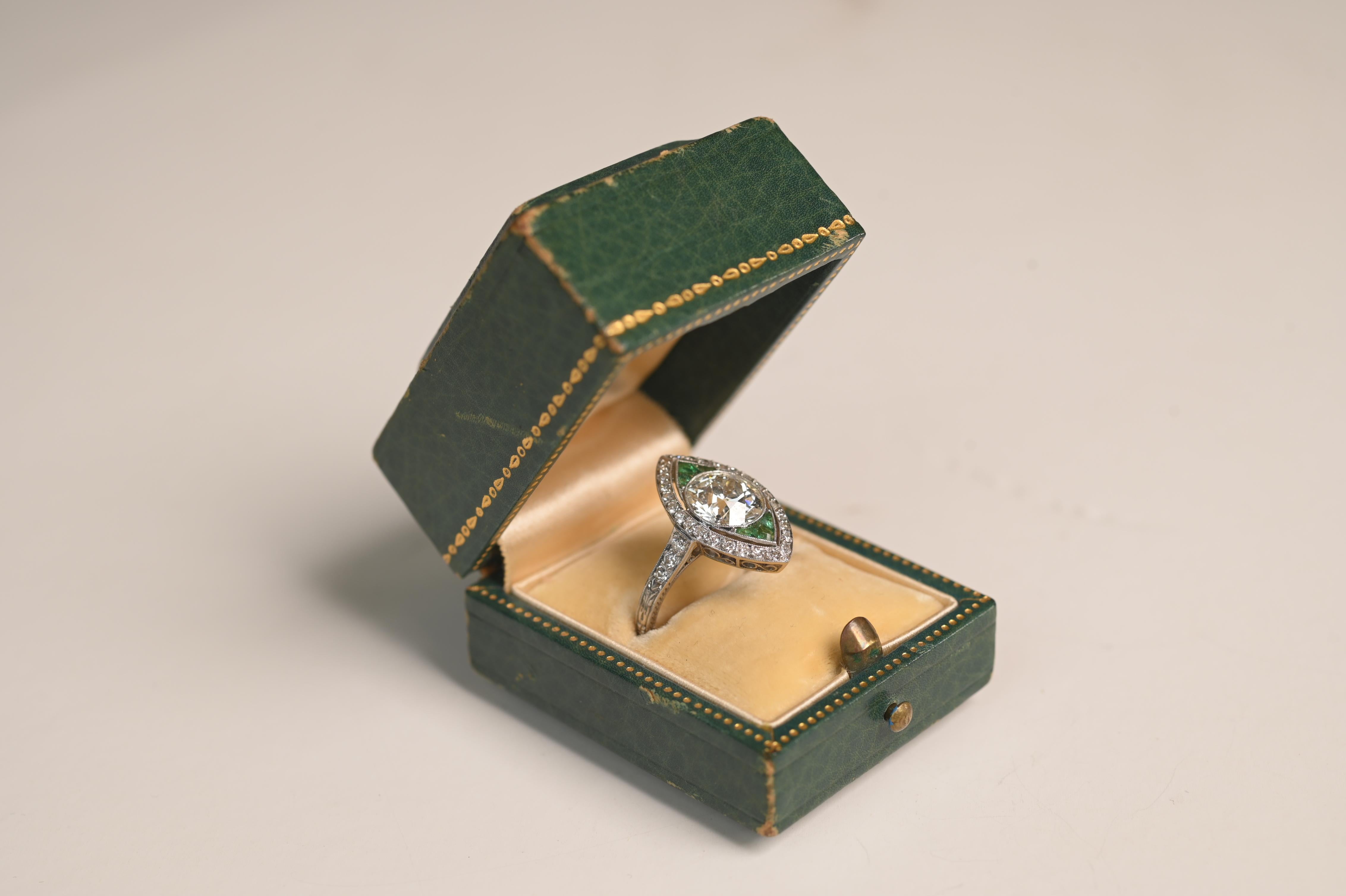 A captivating example of Art Deco craftsmanship, this antique navette ring showcases a dazzling old European cut diamond weighing approximately 2.20 carats. Graded I color and VS2 clarity, the center stone is securely bezel-set, offering both