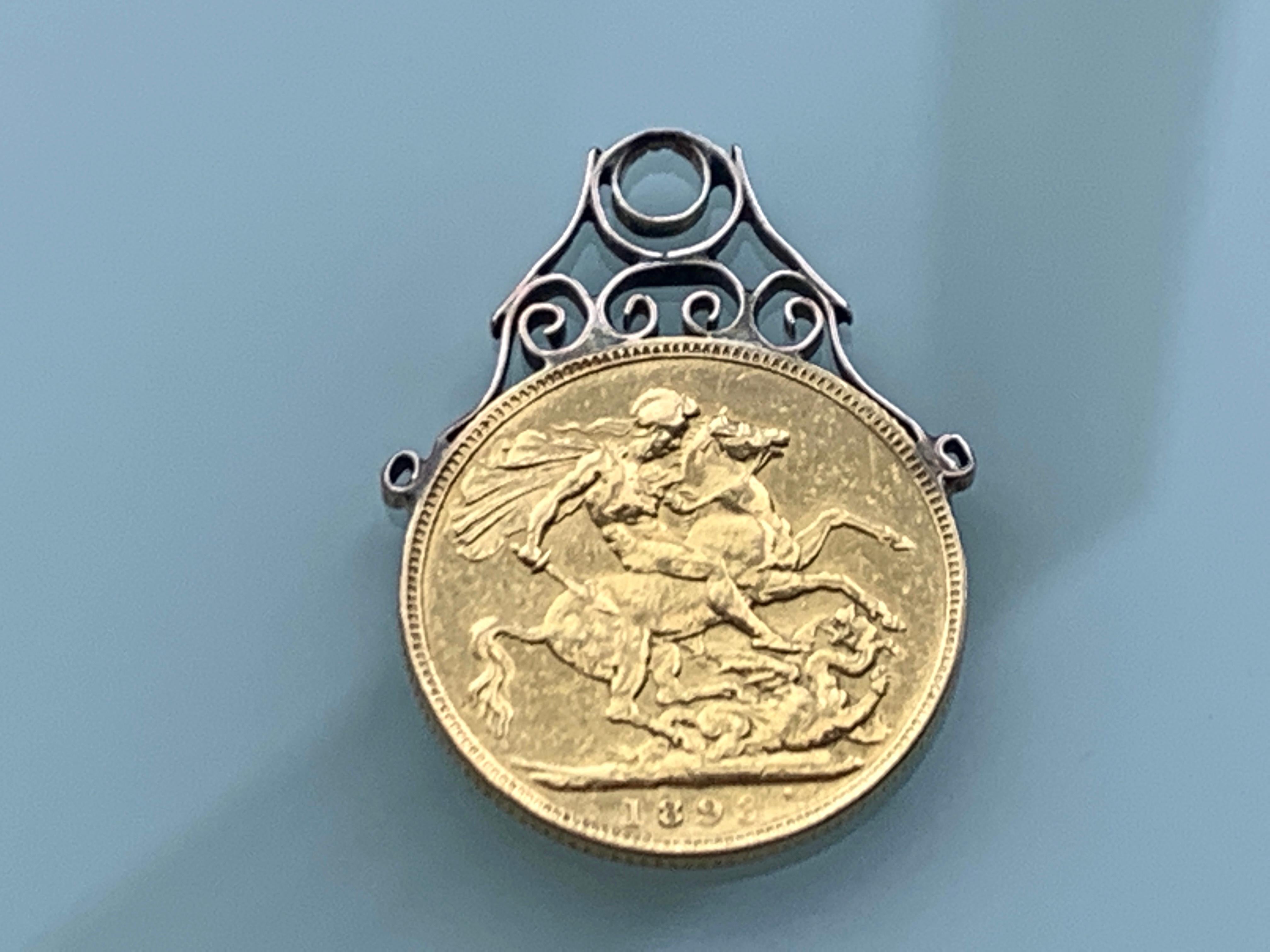 Schöne Antiquität 
22ct Gold Souverän
mit Zierfassung aus 9ct Rose Gold
Die Münze ist auf 1893 datiert.
Gewicht des Souveräns 7,99 Gramm
Gewicht der Halterung 0,59 Gramm.