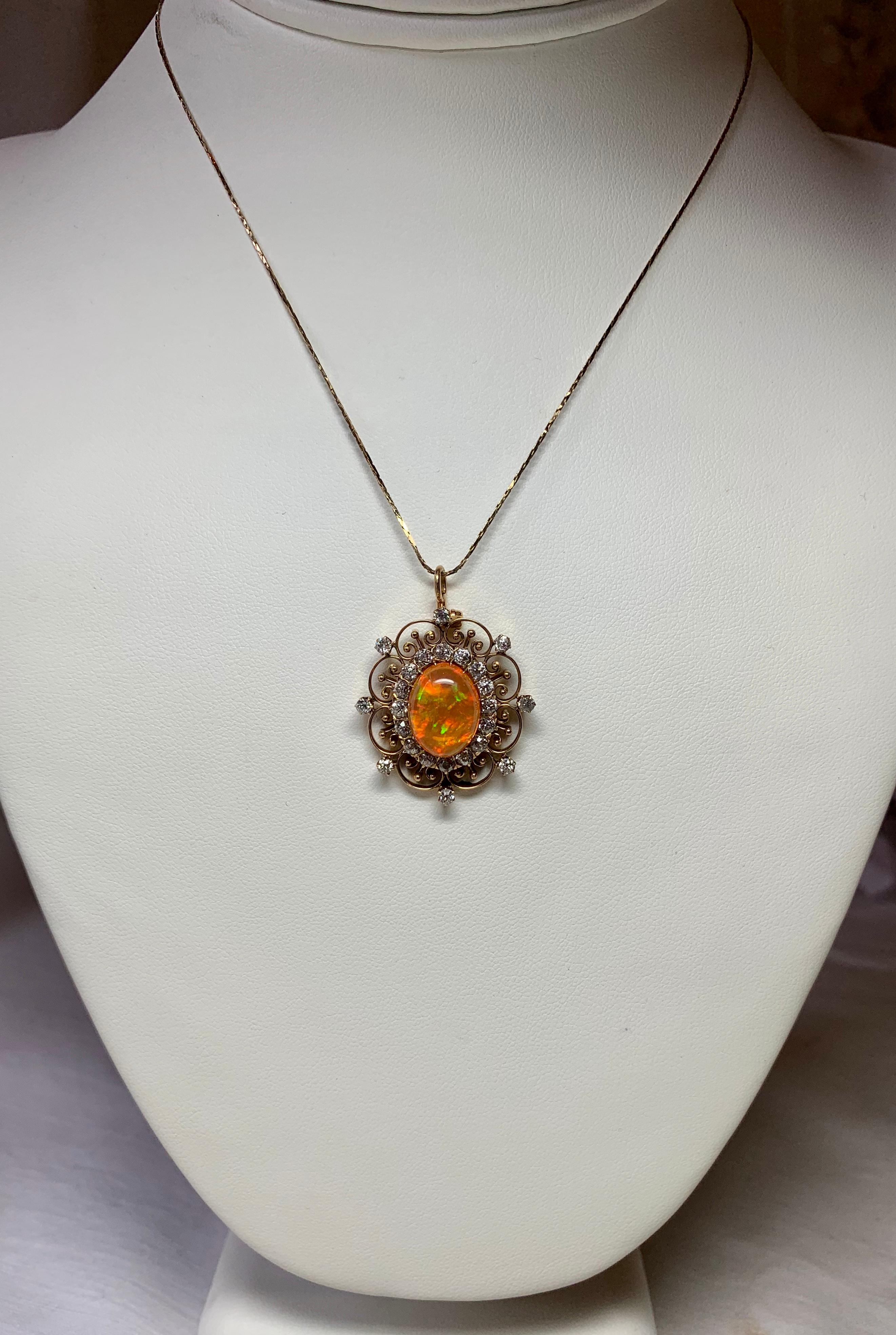 A stunning Antique Art Deco - Victorian Pendant with a gorgeous central 2.4 Carat Opal accented by 23 absolutely radiant Old Mine Cut Diamonds totaling 2.0 Carats.  The oval opal cabochon gem has vivid orange with green accents - stunning!  The