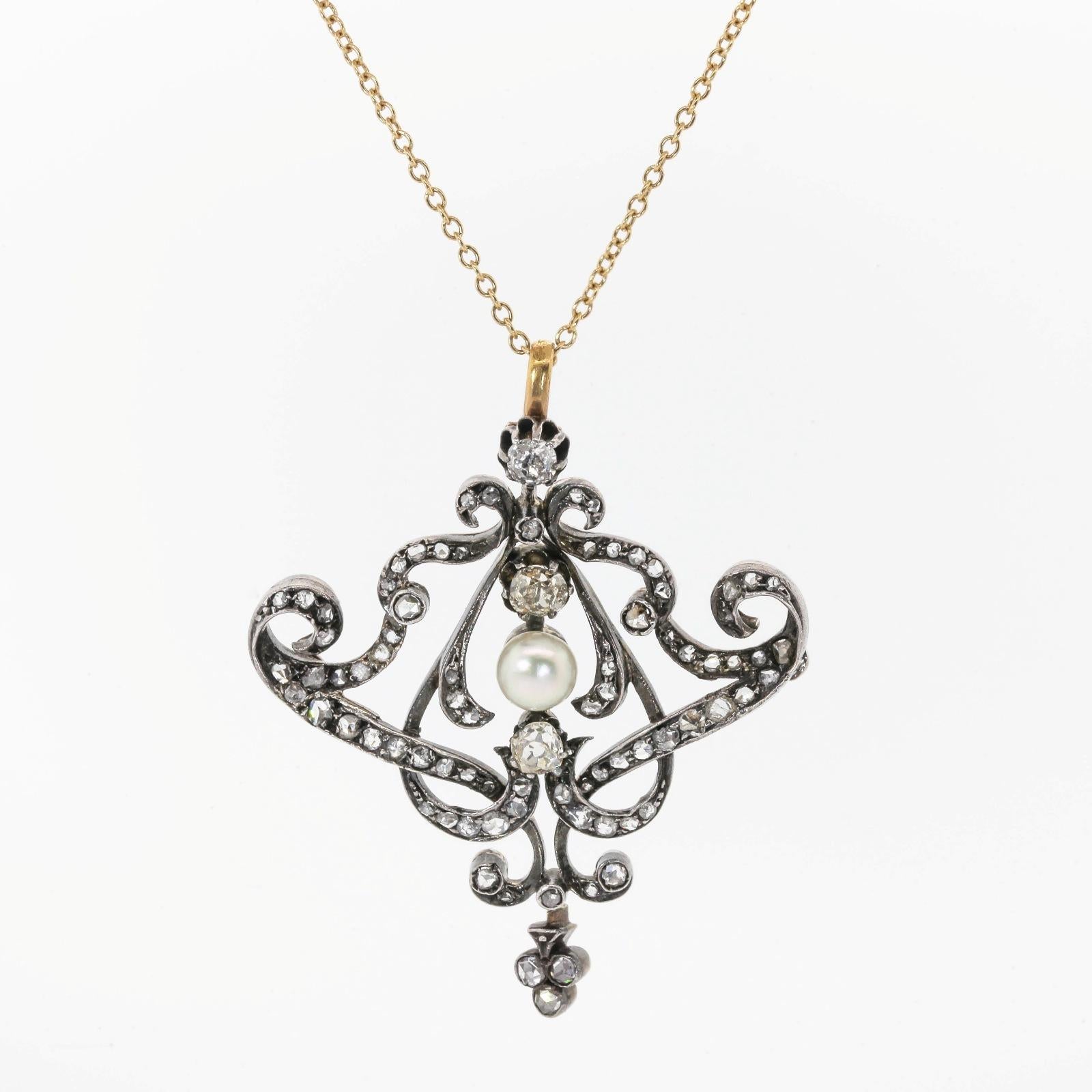 A gorgeous 1860s pendant immaculately crafted in Silver and 18KT yellow gold.  The pendant is  designed of flowing curves, accented with three Old Mine Cut Diamonds and a natural white Pearl at the center.  Rose Cut Diamonds dress up the rest of