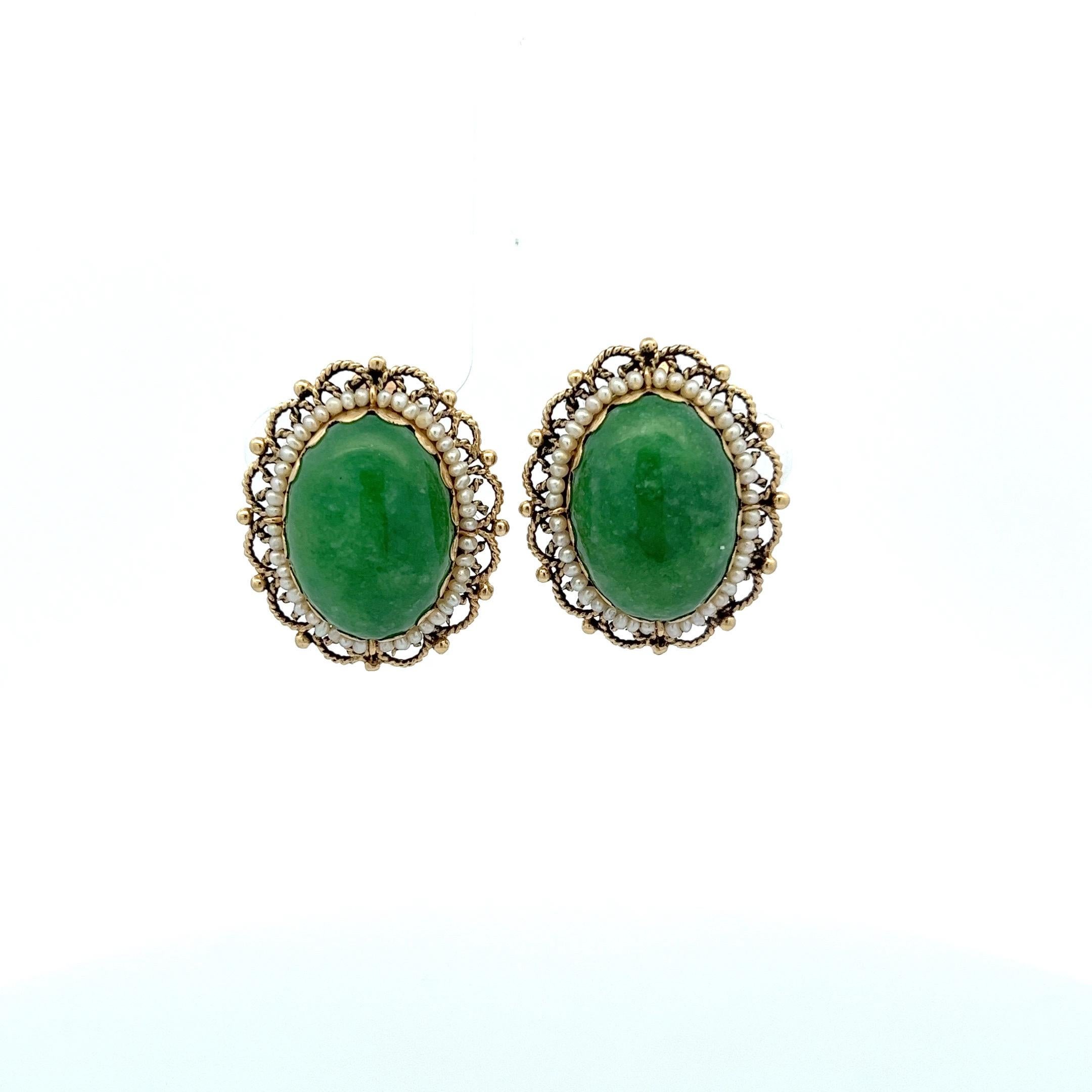 These elegant jade and pearl clip-on earrings are a true statement piece. With a combined weight of 25.7 carats, the stones are gracefully set in 14 karat yellow gold. The jade is framed by a meticulous arrangement of 90 seed pearls, which is