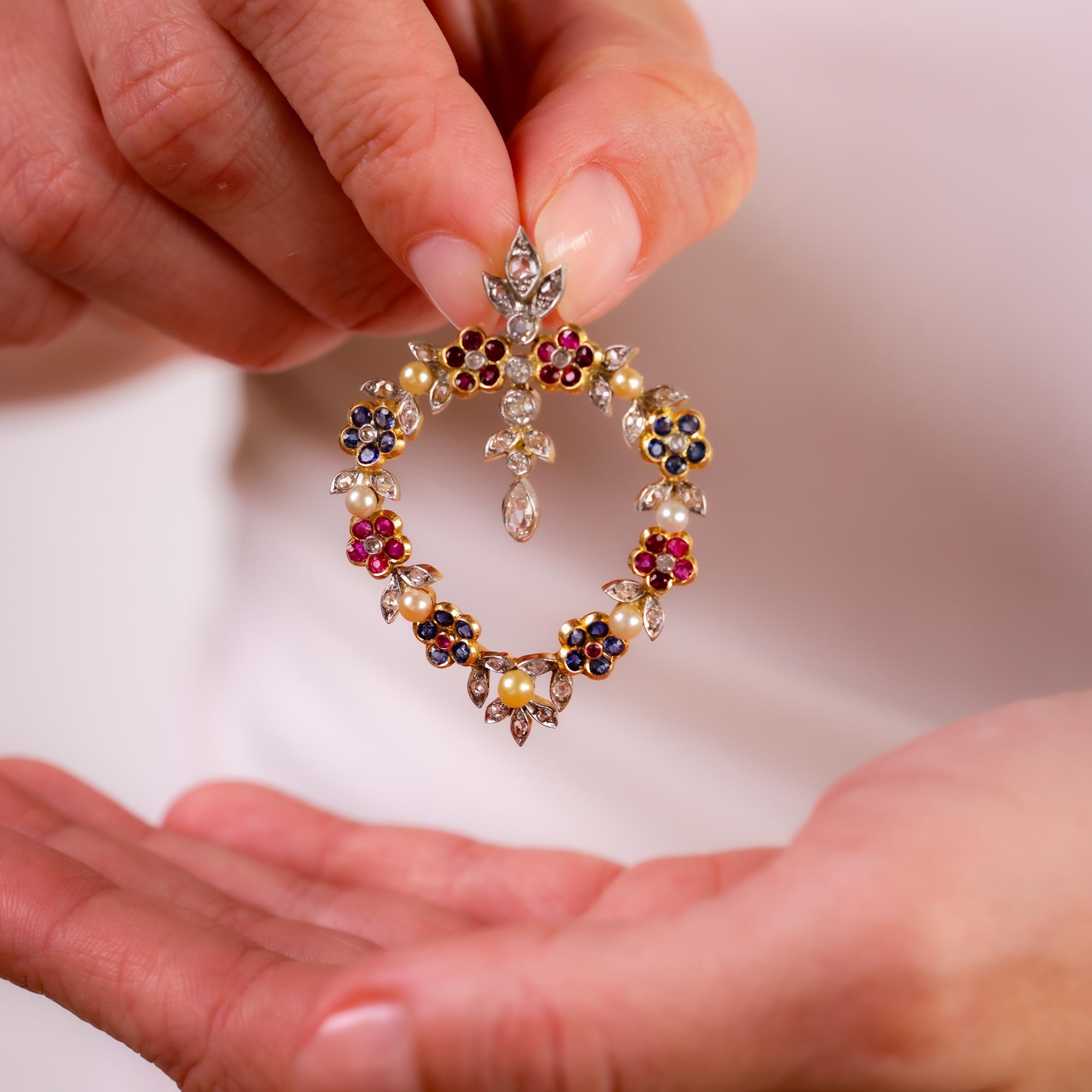 Diese exquisite antike Brosche aus den 1890er Jahren ist aus 18-karätigem Gold und Platin gefertigt und präsentiert eine schillernde Mischung aus Diamanten, Rubinen, Saphiren und Perlen, die ein auffälliges Vintage-Statement abgeben.

Gesamtgewicht
