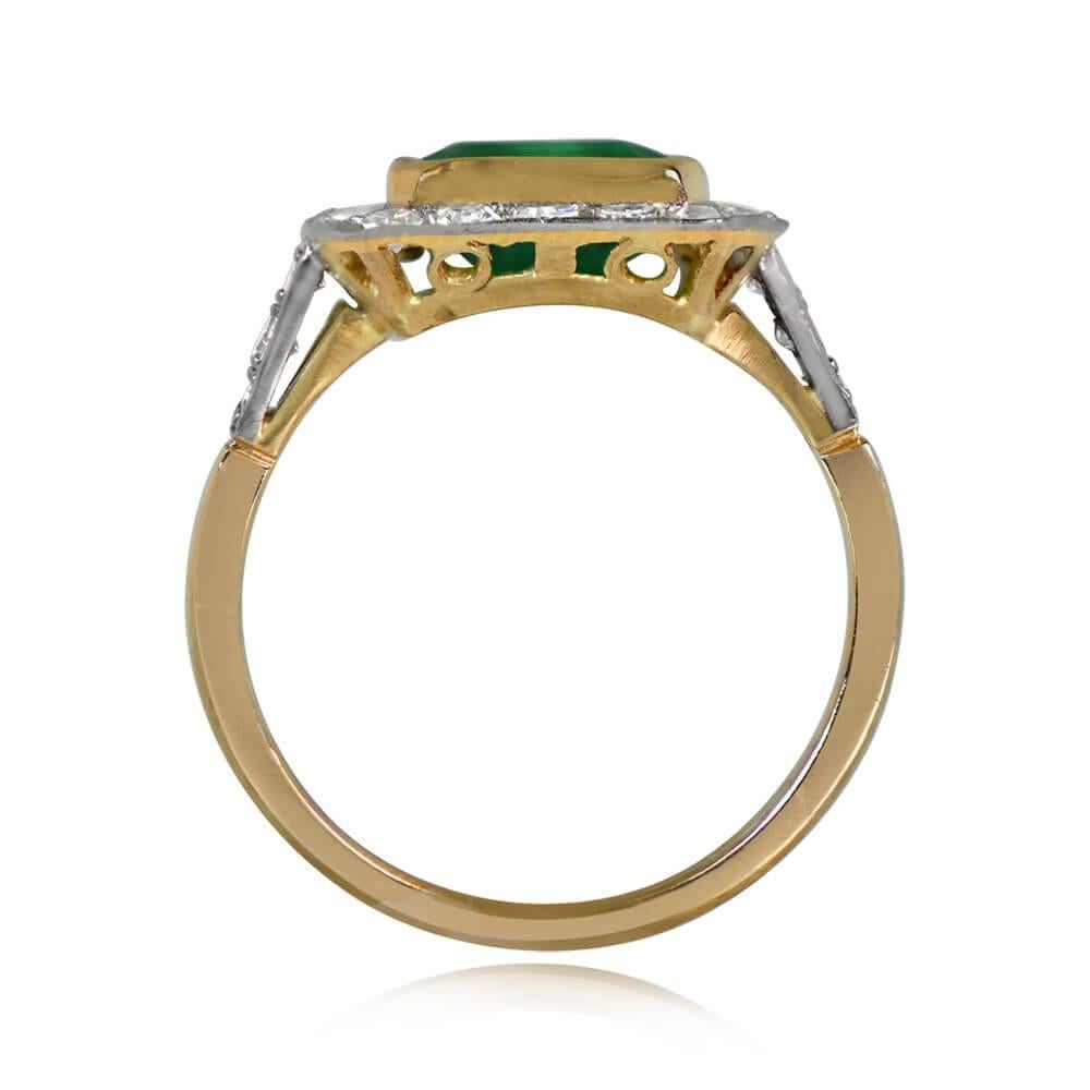 This antique Art Deco ring boasts a stunning 2.62-carat natural Colombian emerald set in yellow gold, surrounded by a sparkling halo of single-cut diamonds. The diamond accents continue along the shoulders, totaling approximately 0.47 carats. The