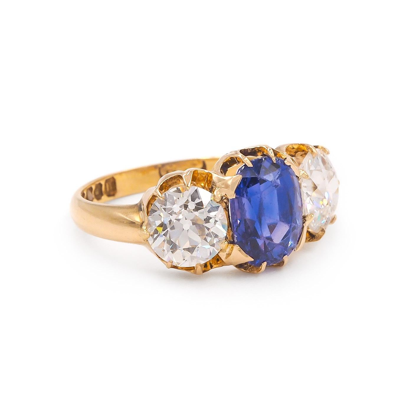 English Origin Edwardian era 2.75 Carat Oval Cut Sapphire & 2.14 Ctw. Old European Cut Diamond 3-Stone Ring, composed of 18k yellow gold. The center 2.75 carat Oval Cut blue sapphire is AGL certified, Ceylon origin and with No Evidence Of Heat