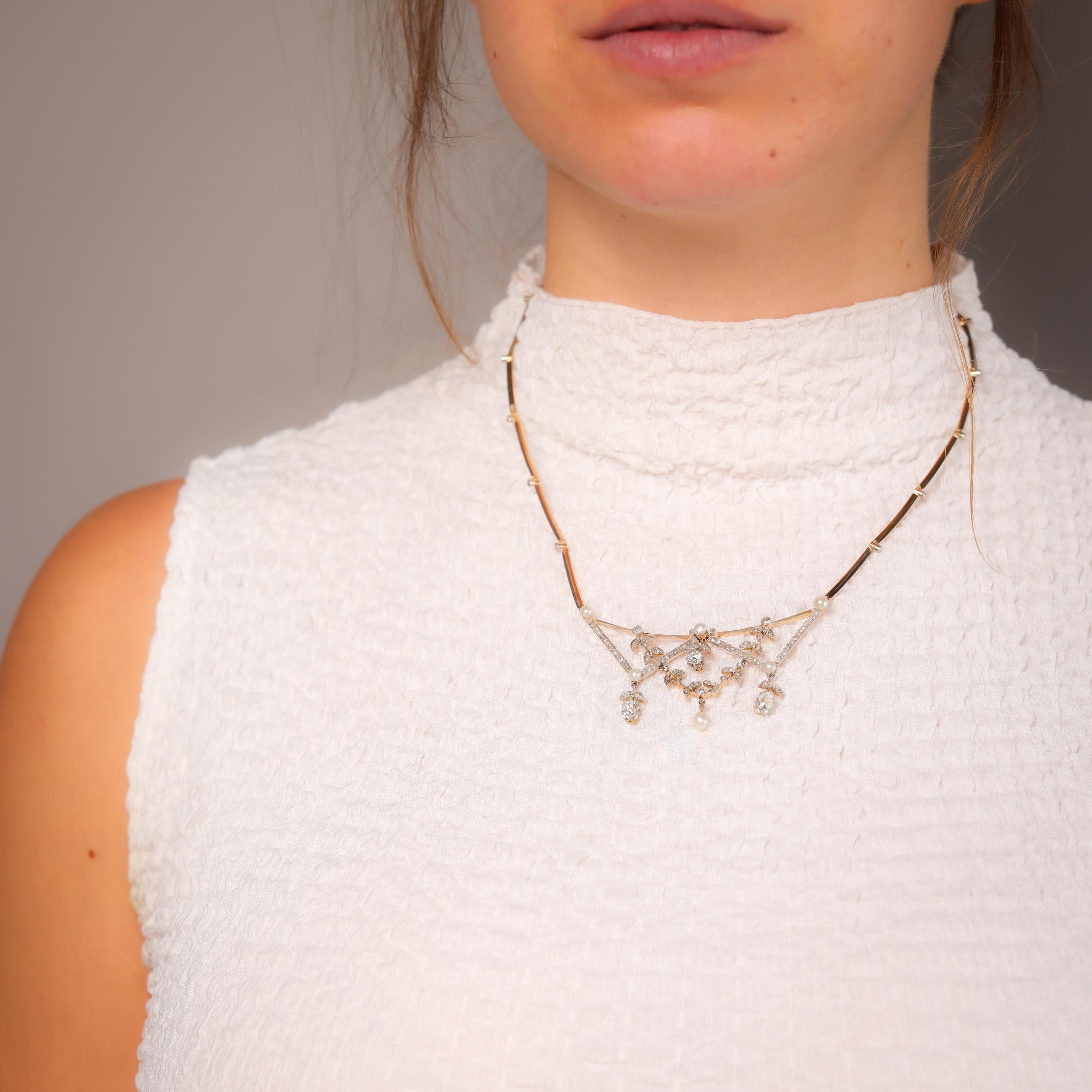 This antique hinged necklace features dazzling old-cut diamonds and lustrous pearls, gracefully set in 18k yellow gold with platinum accents. A breathtaking treasure from the 1890s.

Center stone: 2 old mine, one old European, and 124 rose cut