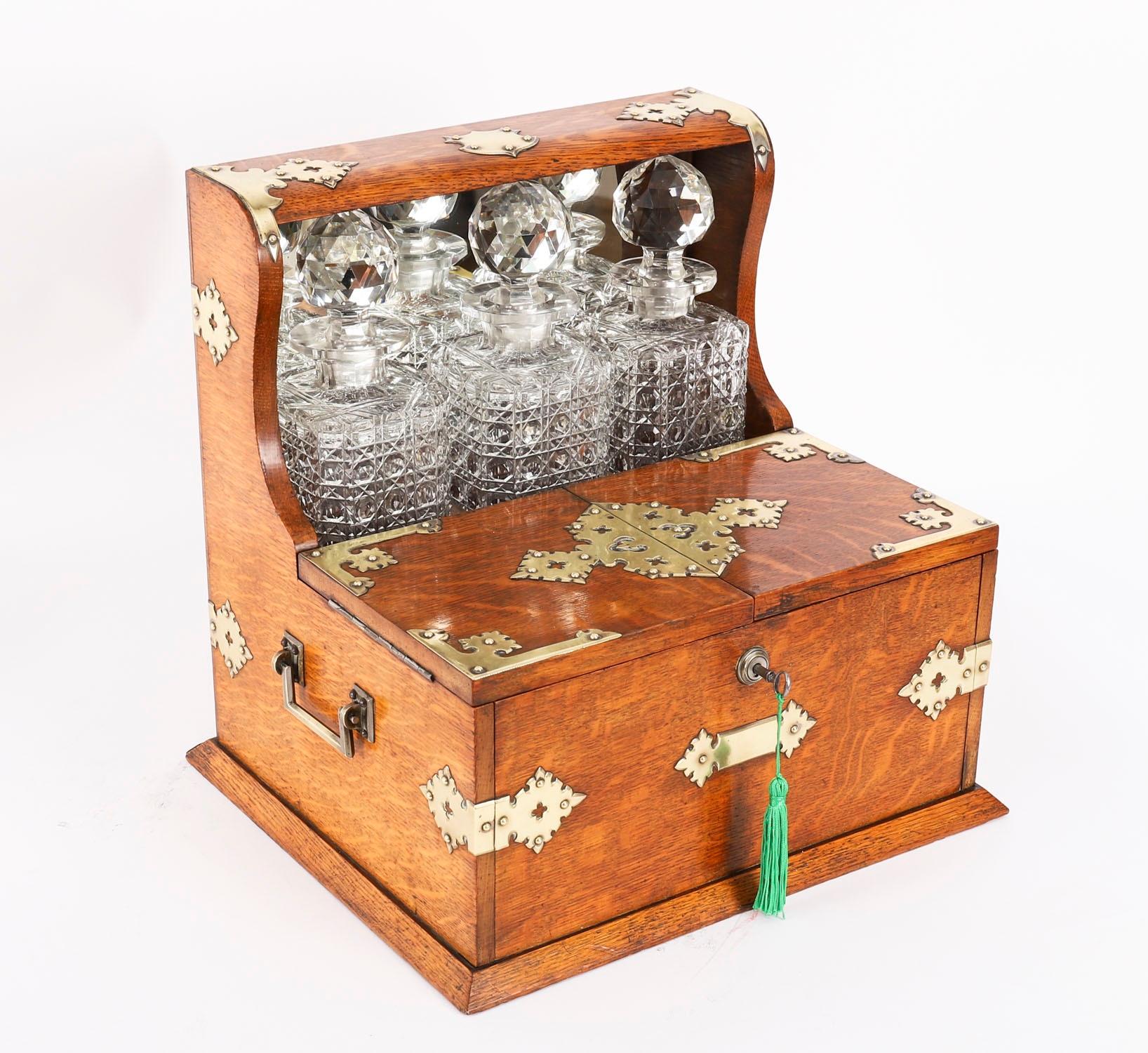 Il s'agit d'un superbe tantale victorien ancien en chêne doré à trois carafes, avec des montures décoratives en laiton taillé de style néo-gothique et des poignées de transport en laiton sur les côtés, datant d'environ 1880.

Ce magnifique tantale