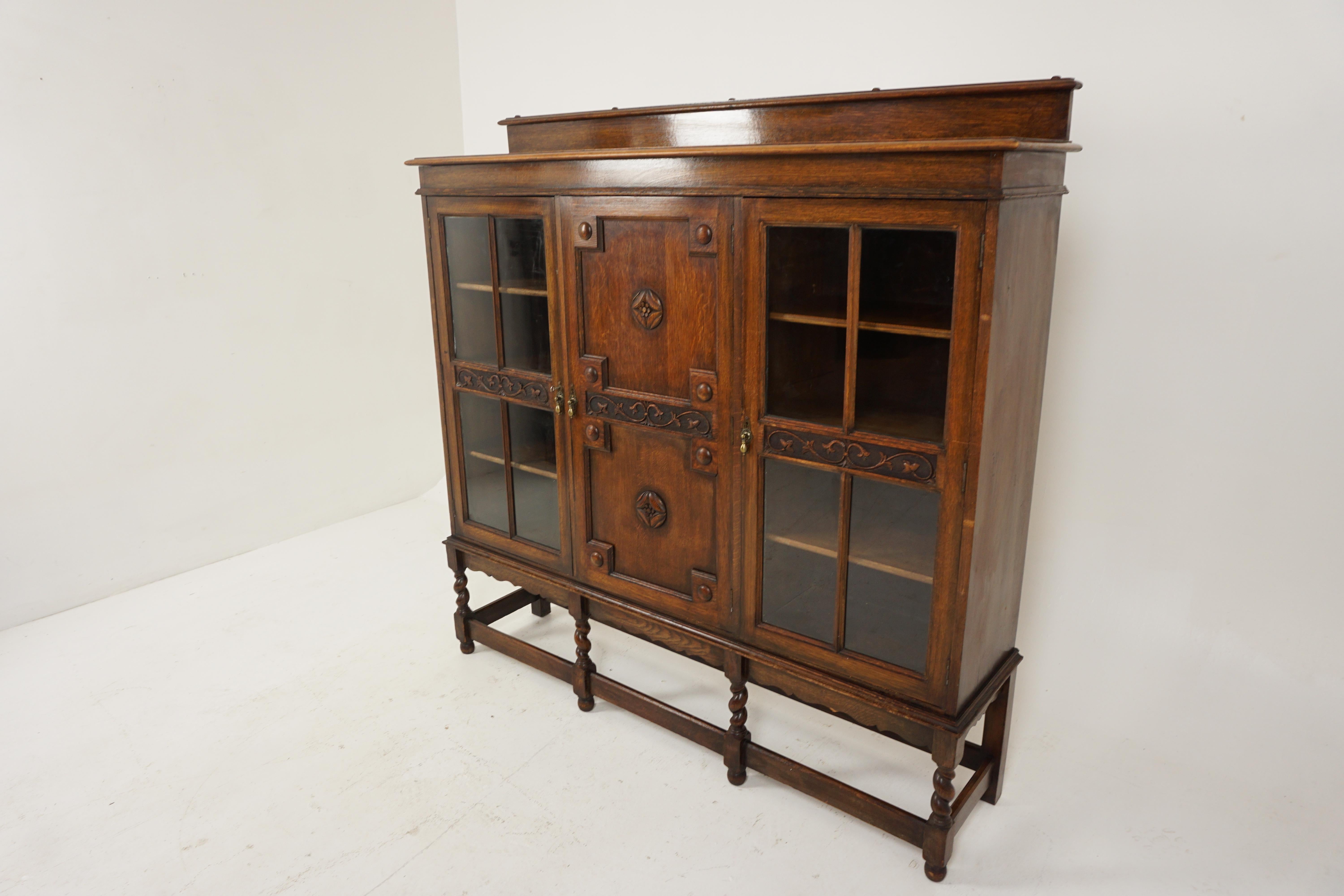Antique 3 Door Barley Twist Oak Bookcase display cabinet, Scotland 1920, B2665 

Scotland 1920
Solid Oak
Original Finish
Has a rectangular top with pediment 
Under you have a single paneled door with rondels to the front
Flanked by a pair of