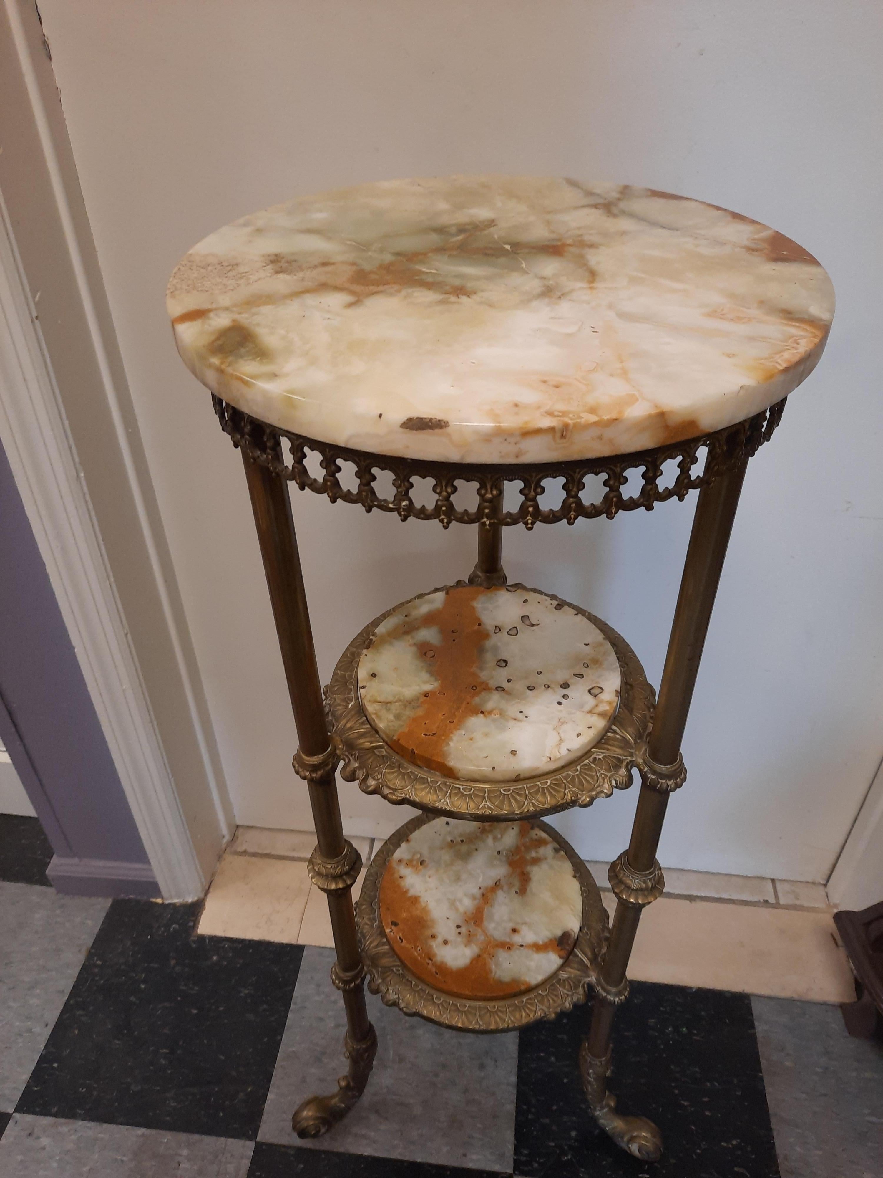 Antique 3 tier marble and solid brass pedestal/stand. Beautiful details and patina on the brass, please see photos for details. The three display areas are topped with a unique marble that sits in the brass frame for security. The top marble sits on