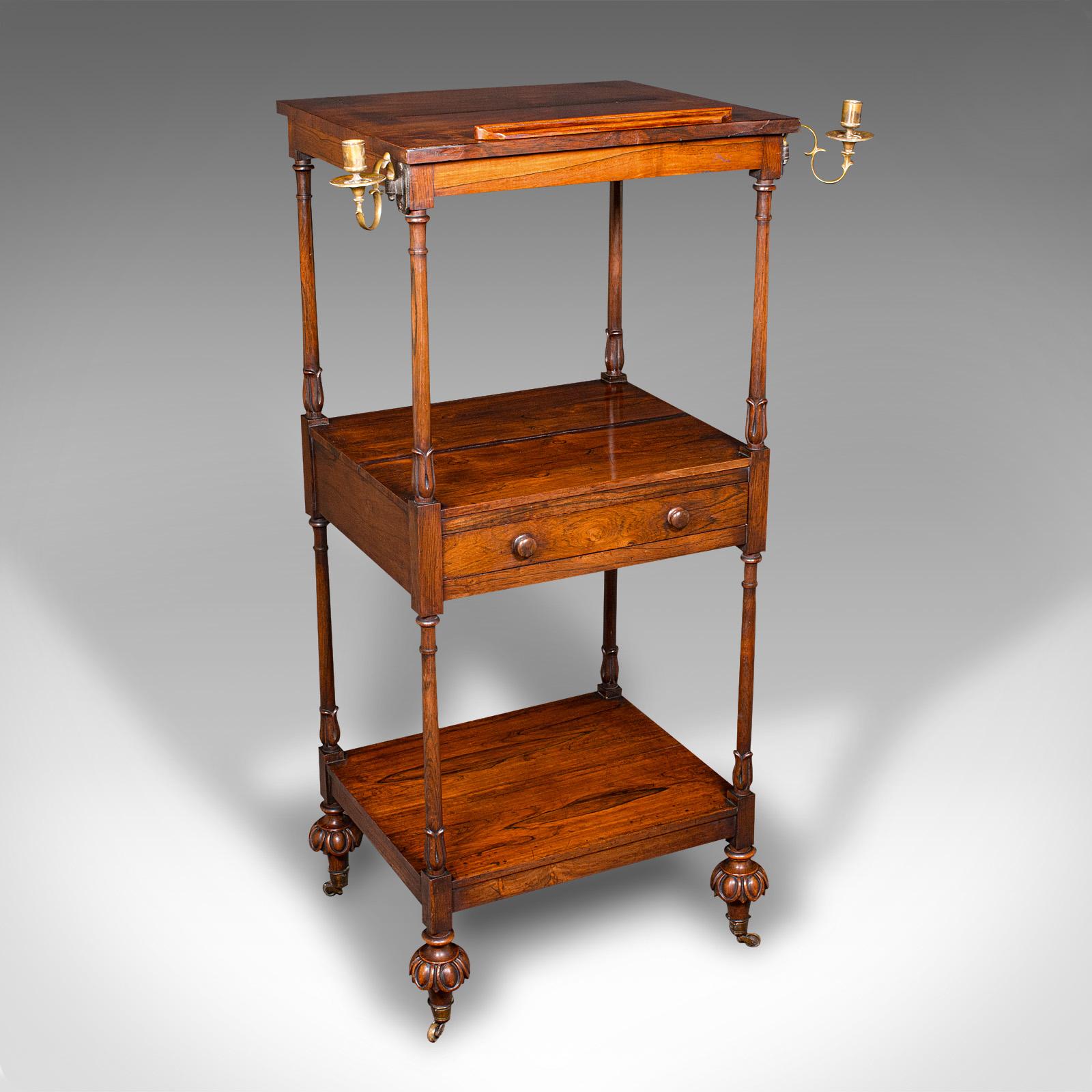 
This is an antique three tier music stand. An English, rosewood whatnot with articulated lectern rest, dating to the Regency period, circa 1820.

Delightful music stand, with fine Regency craftsmanship
Presents a desirable aged patina and in good
