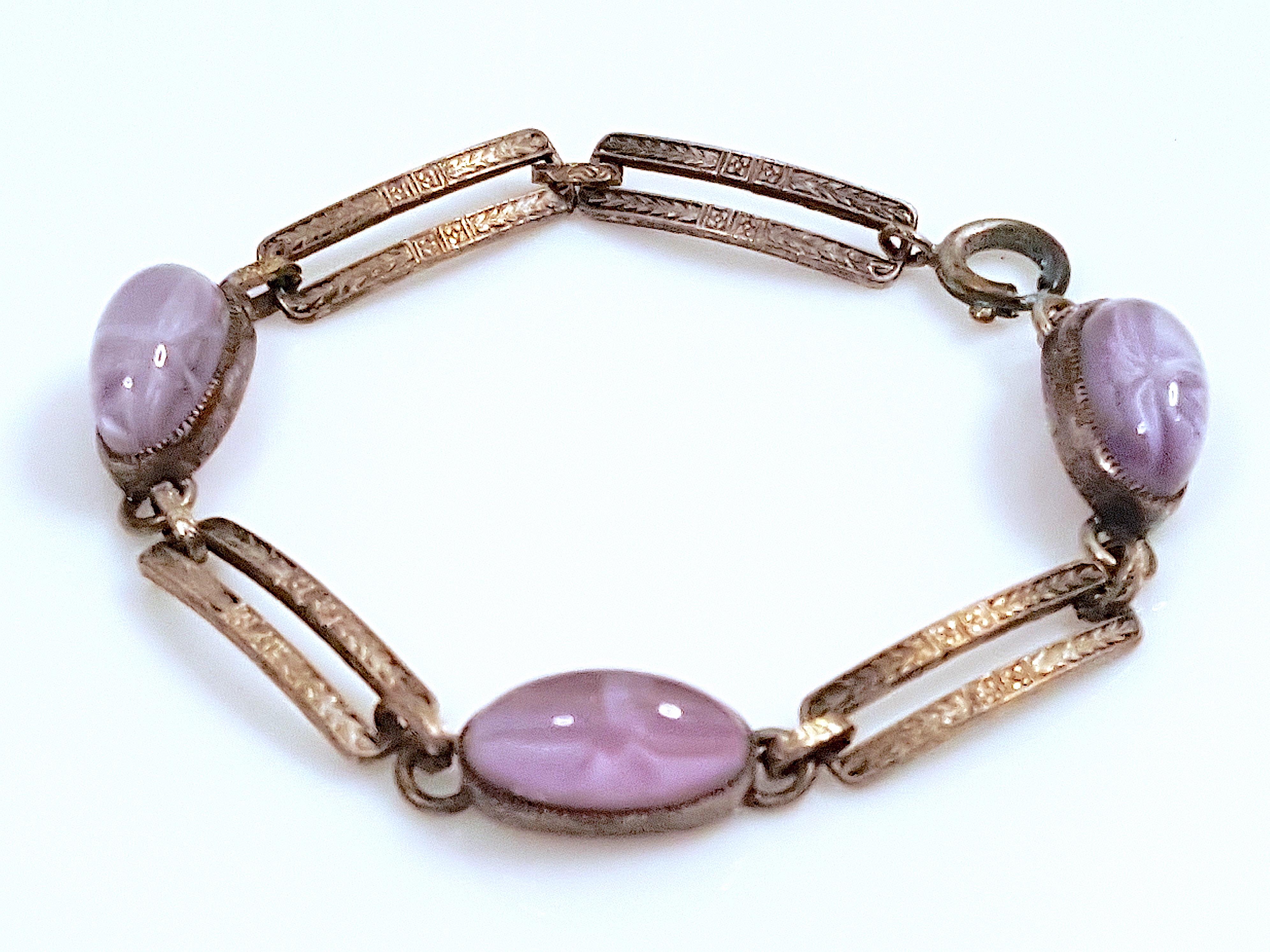 Three violet purple star sapphire high-dome oval cabochons that transition from transparent to opaque are bezel set in this antique white-gold chain link tennis bracelet made during the Belle-Epoque-meets-Art-Deco period. The lavender hues in