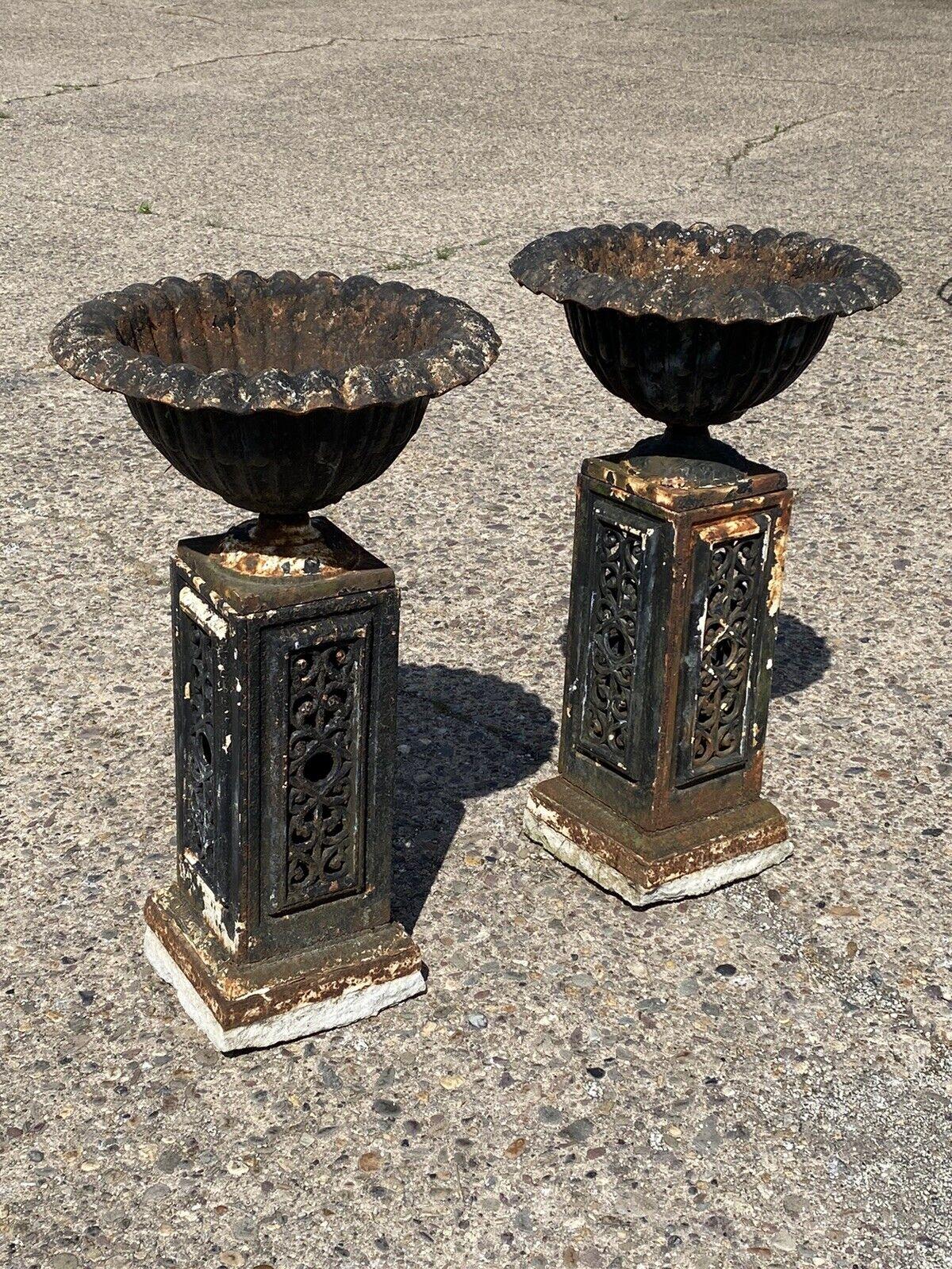 Antique French Victorian cast iron fluted urn garden planter pedestal - a pair. Item features a cast iron construction, fluted urn forms, ornate cast iron pedestal bases, authentic weathered finish, great style and form. Circa 19th century.