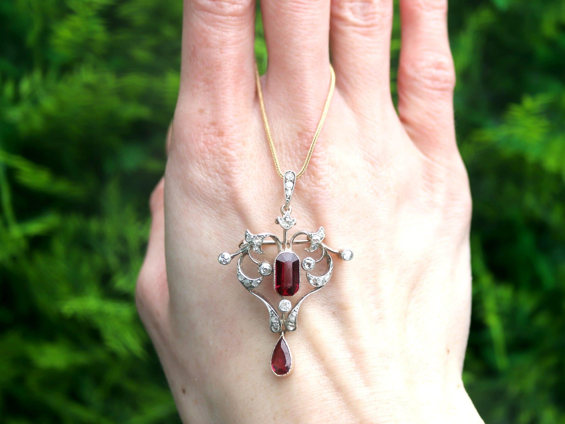 A fine and impressive antique 3.22 carat garnet and 0.61 carat diamond, 9 karat yellow gold and silver set pendant / brooch in the Belle Époque style; part of our diverse antique jewelry and estate jewelry collections.

This fine and impressive