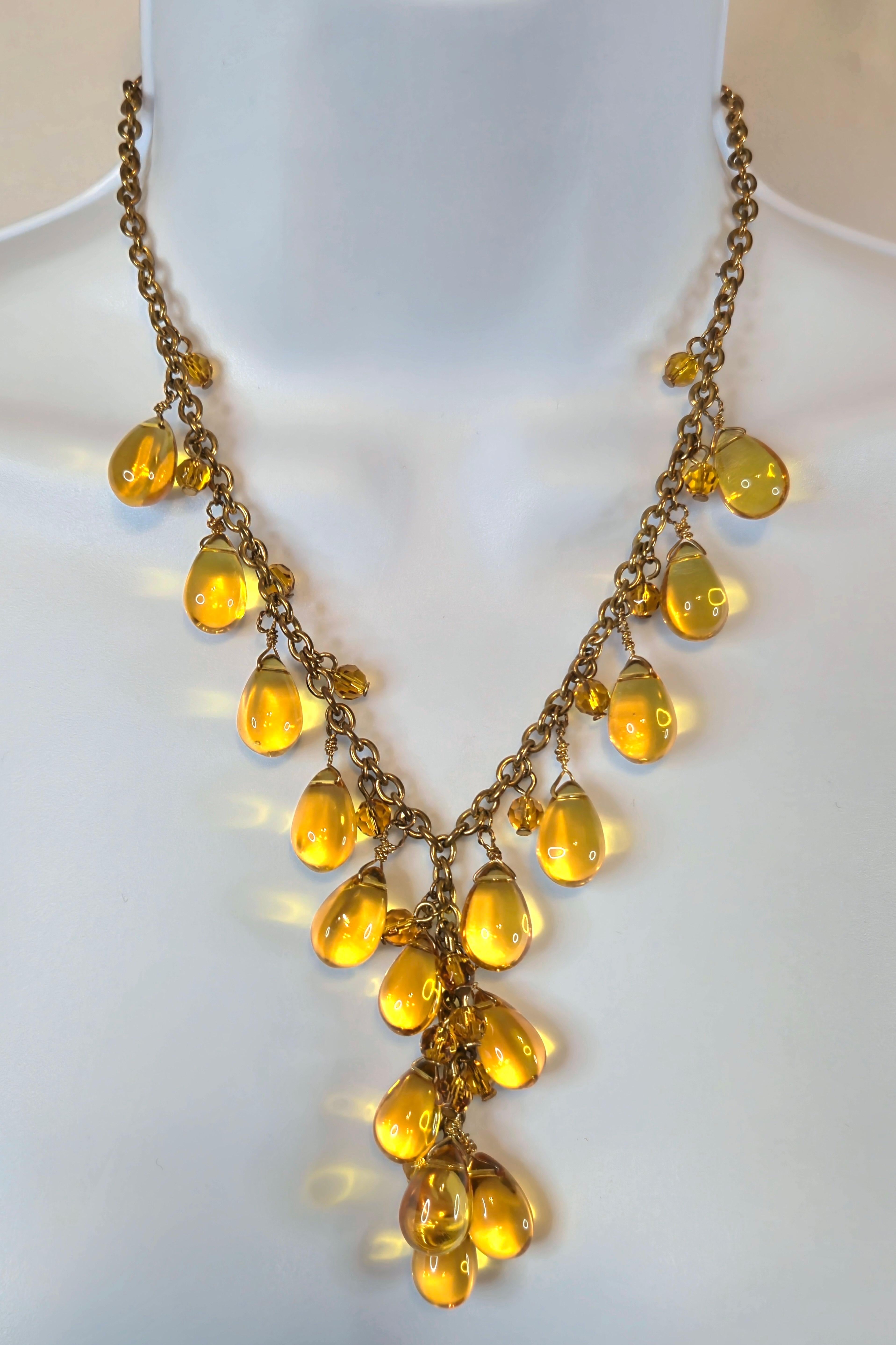 This antique French chain necklace with three-inch drop features 33 natural citrines including 16 polished-teardrop and 17 faceted-bead golden quartz. It was constructed by hand from bronze wire and fastens with a lobster clasp like jewelry made in