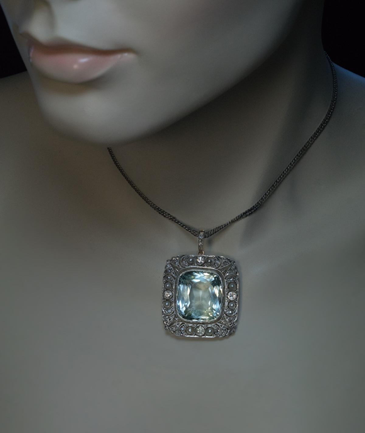 Circa 1905

This exquisite antique pendant from the Edwardian era features a huge cushion cut 34.25 ct aquamarine of excellent color, clarity, and polish. The aquamarine measures approximately 21.16 x 18.14 x 12.22 mm. The center stone is set in an