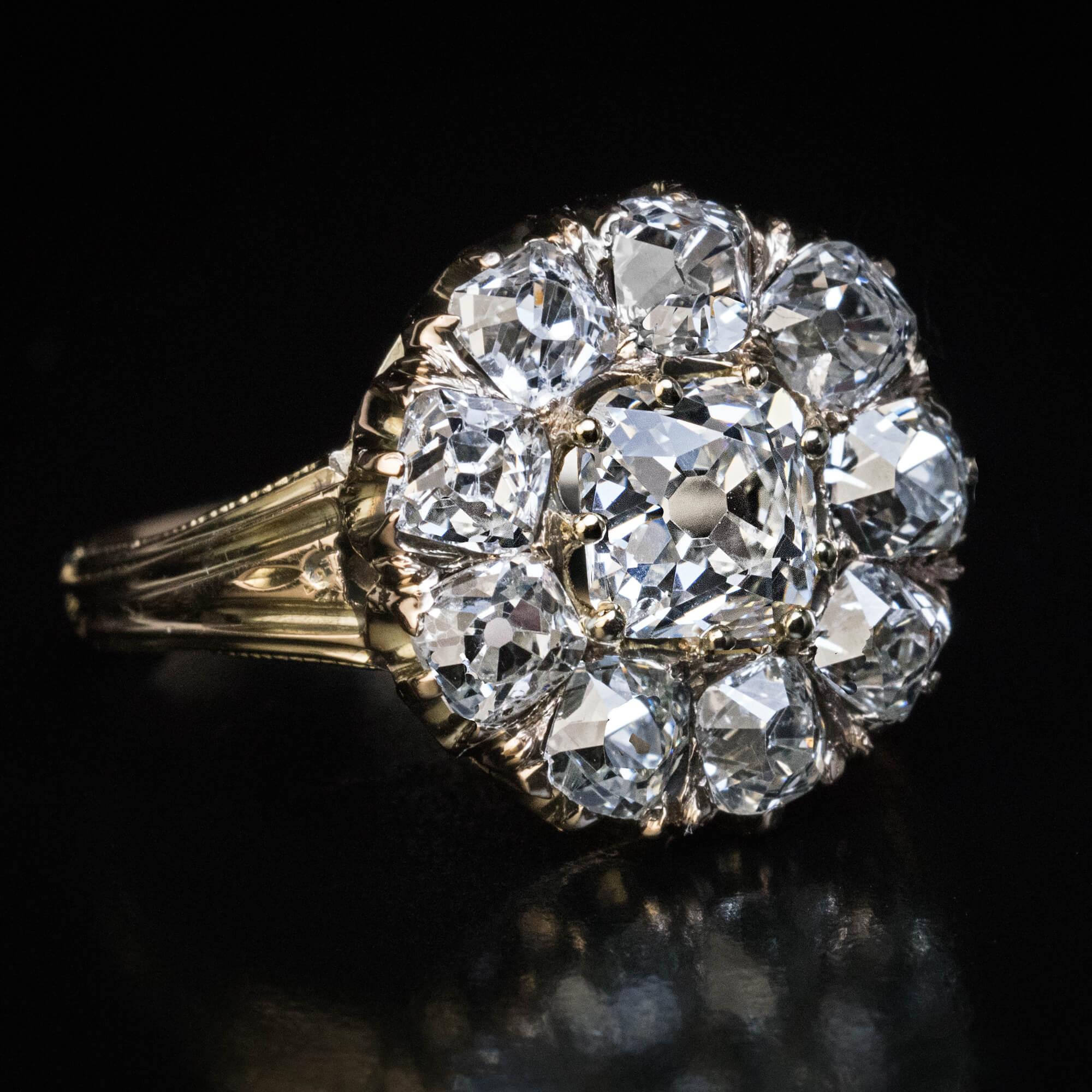 Circa 1880  This classic Victorian era 14K gold cluster ring features chunky and very clean old cushion cut diamonds.  Weight of the principal diamond is 1.04 carats (I color, VS1 clarity).  The center stone is surrounded by nine sparkling diamonds