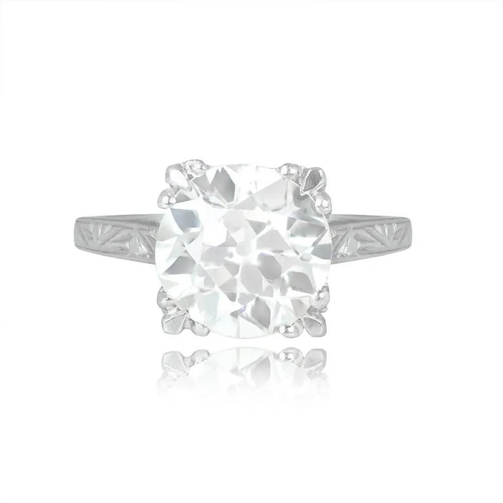 An Art Deco diamond solitaire engagement ring showcasing a 3.63-carat old European cut diamond, J color and VS2 clarity. The diamond is set in box prongs. The ring features intricate hand engravings and delicate milgrain detailing on the prongs,