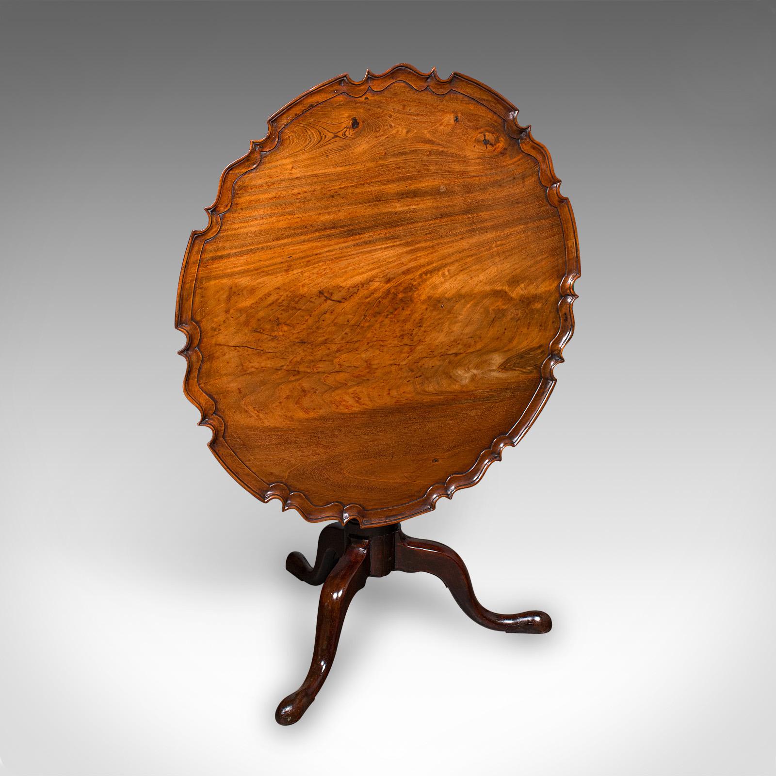 This is an antique 4 seat occasional table. An English, walnut and mahogany tilt-top pie crust serving table, dating to the Georgian period, circa 1800. A superbly crafted and generously proportioned example of fine Georgian furniture, displaying