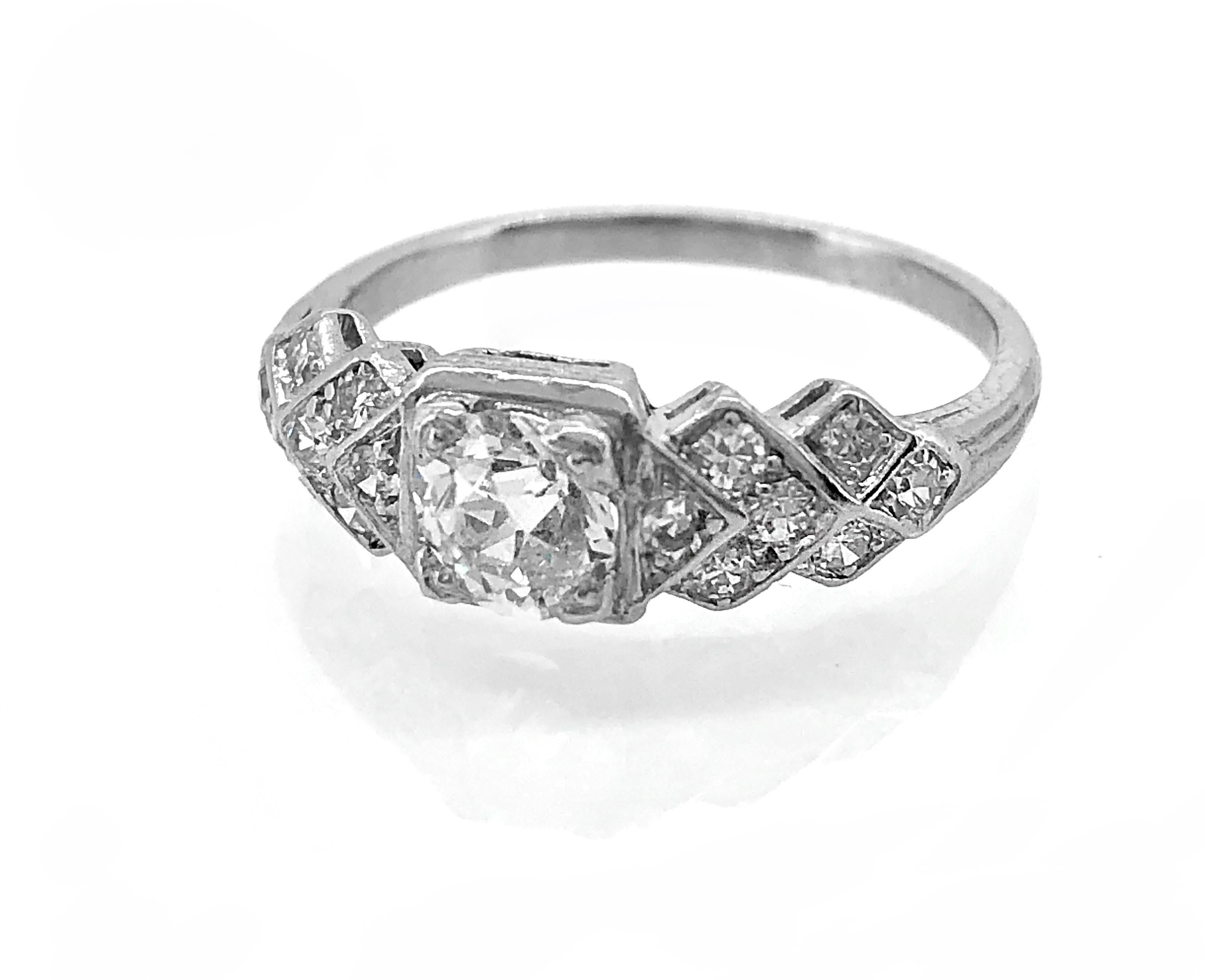 A bright and sparkling diamond Antique engagement ring, from the Art Deco time period, features a .43ct. apx. European cut diamond with VS2 clarity and K-L color. The accenting single cut diamond melee decorates the sides of the center diamond and