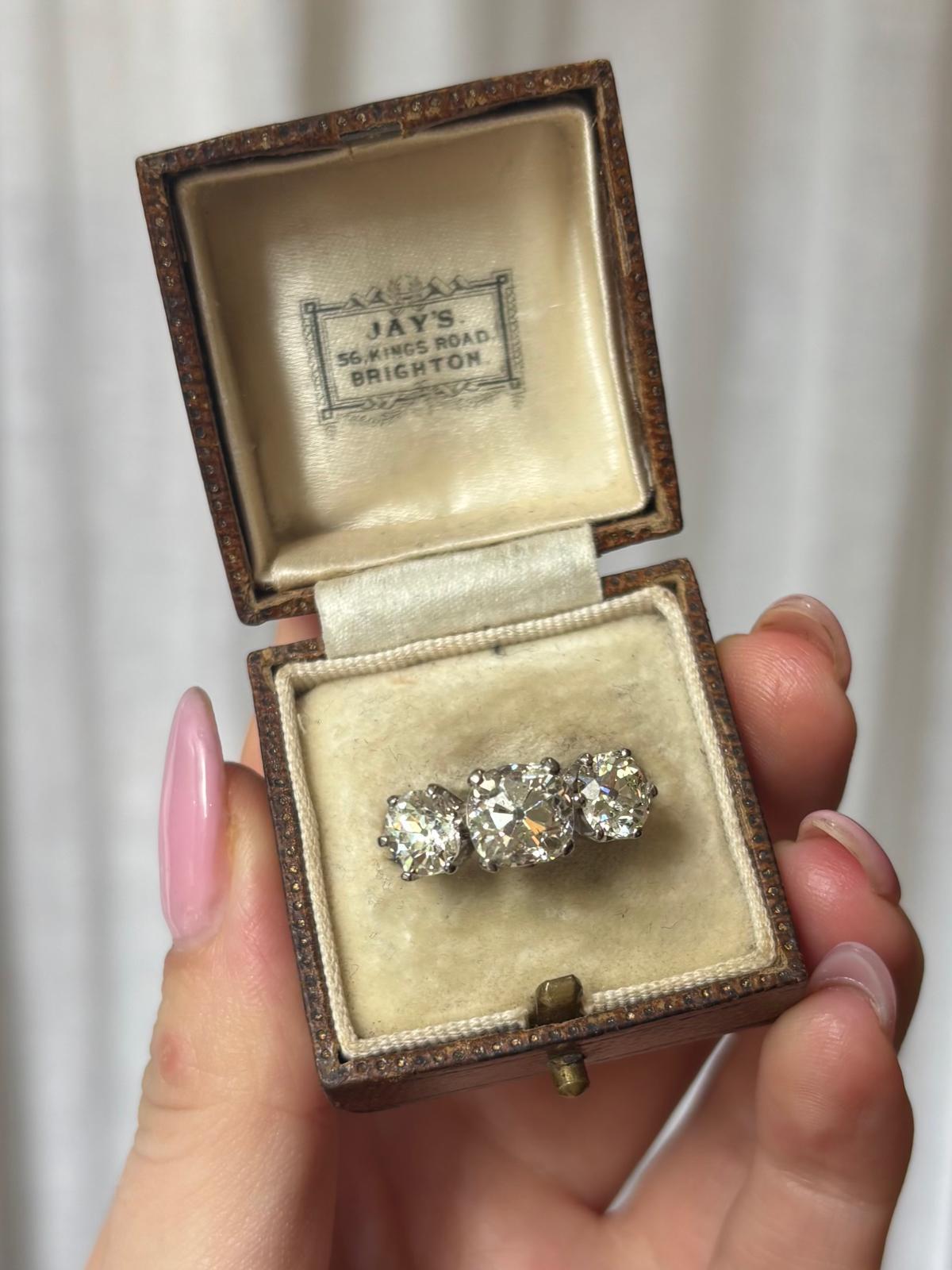 A sparkly antique old mine cut diamond three stone ring set in 18k white gold. 

This classic piece is set with three old mine cut diamonds, each set in their own white gold claw setting. The graduation between the central stone and side stones in