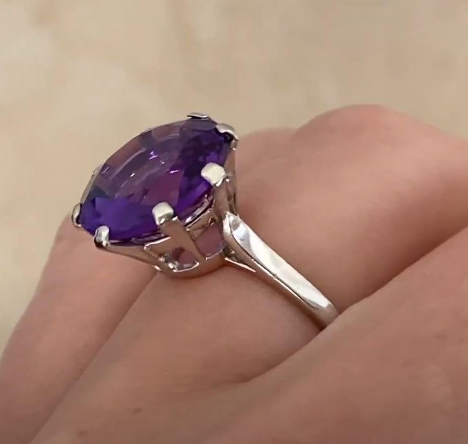 This striking antique ring showcases a magnificent approx. 4.60-carat round-cut amethyst, exuding a deep, regal hue. The captivating center stone is securely cradled by eight meticulously crafted prongs, allowing light to enhance its brilliance from