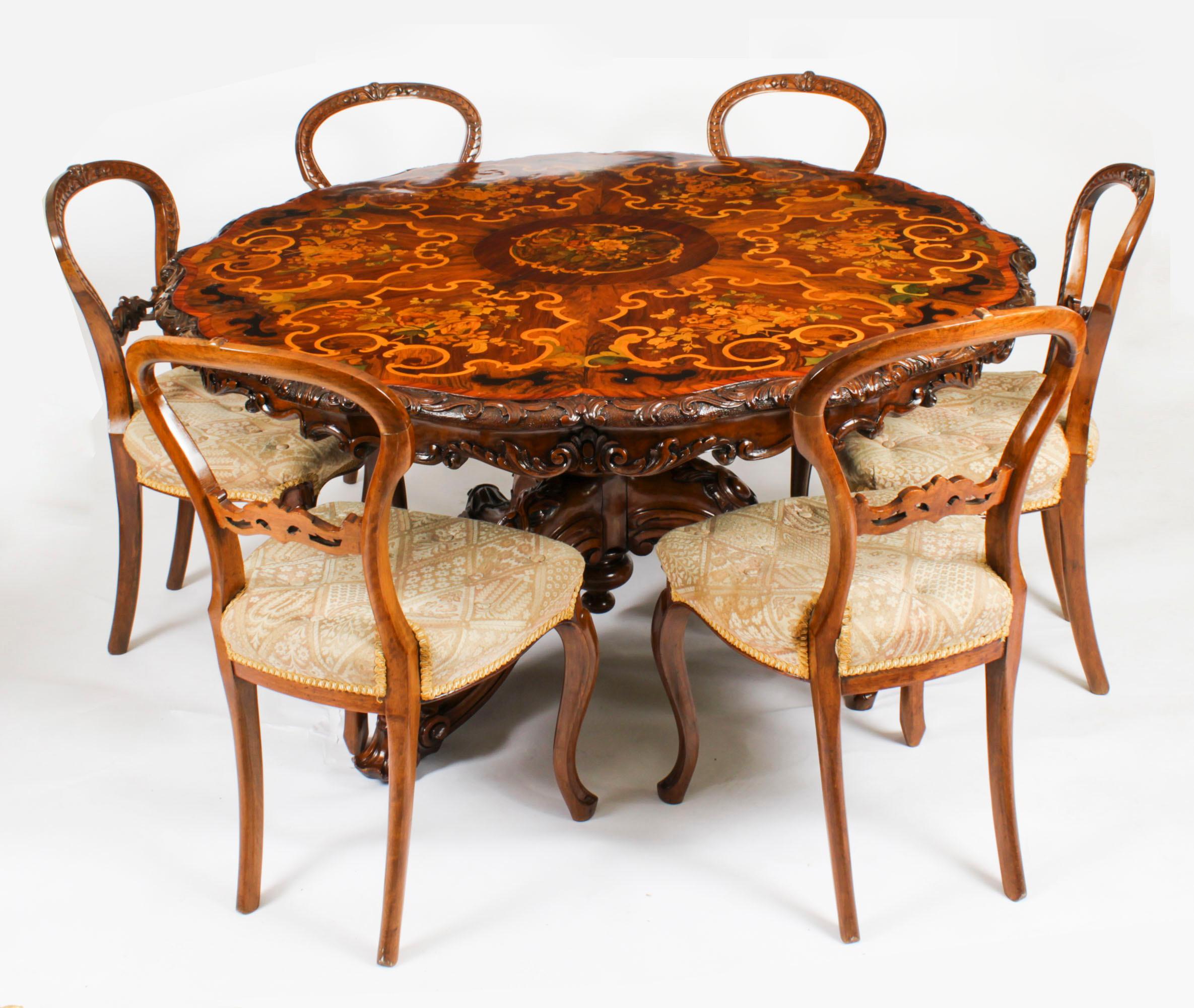 Il s'agit d'une belle et rare table centrale en ronce de noyer, bois de tulipe, ébénisterie et marqueterie de bois fruitier, de style anglais moyennement victorien, à la manière d'Edward Holmes Baldock et datant d'environ 1860.

Le plateau