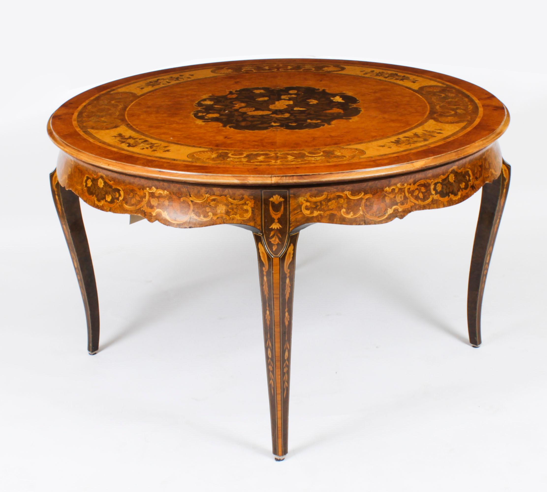 This is a lovely antique Victorian burr walnut and marquetry centre table, circa 1900 in date
 
The circular 4ft diameter table top features superb inlaid scrolling floral marquetry decoration on a stunning burr walnut ground, with a cross-banded
