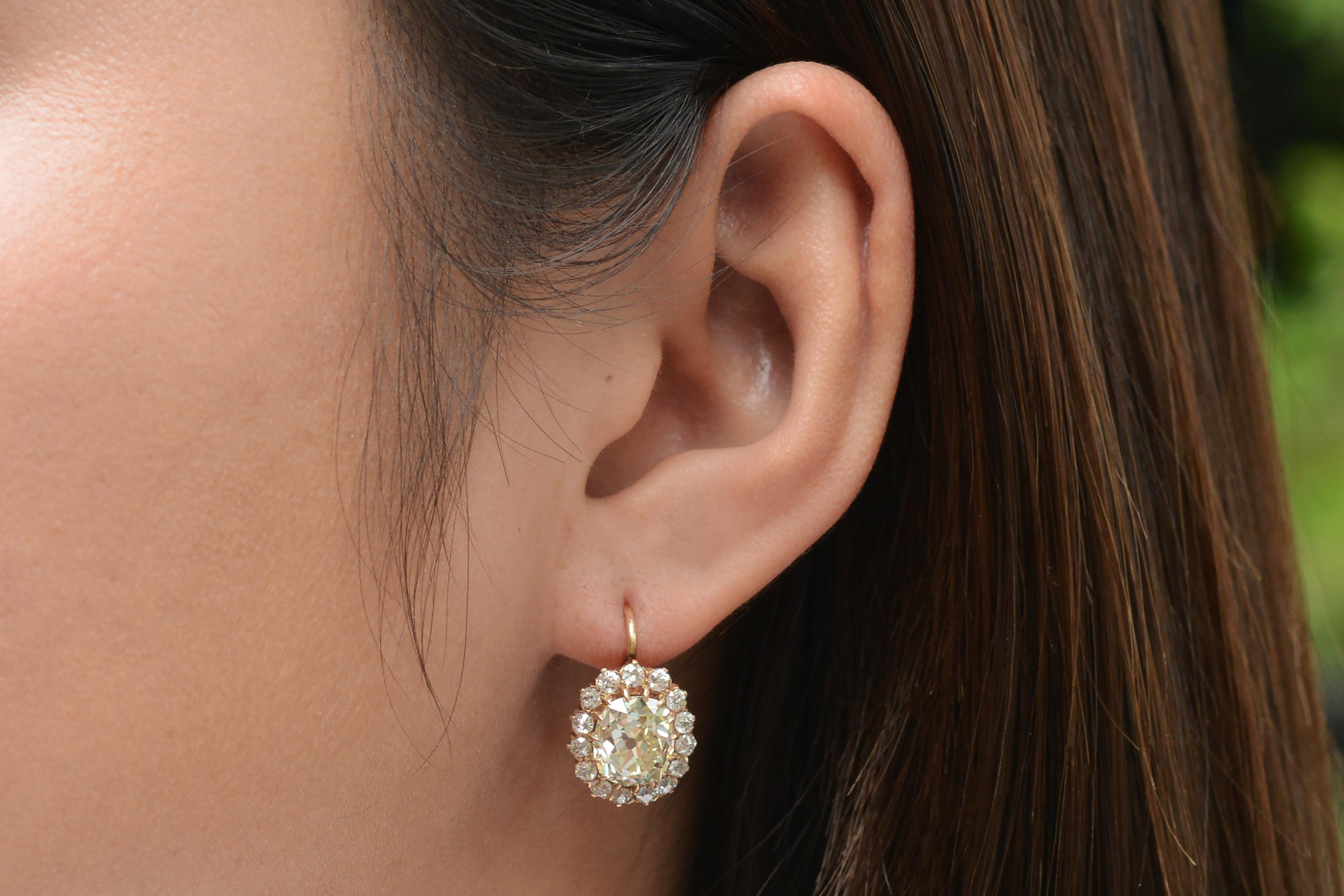 It truly is love at first sight with this phenomenal pair of 5 carat antique old mine cut diamond lever-back earrings. In each one sits an over 2 carat antique cushion cut diamond that was cut with a foot powered treadle using thorough care and